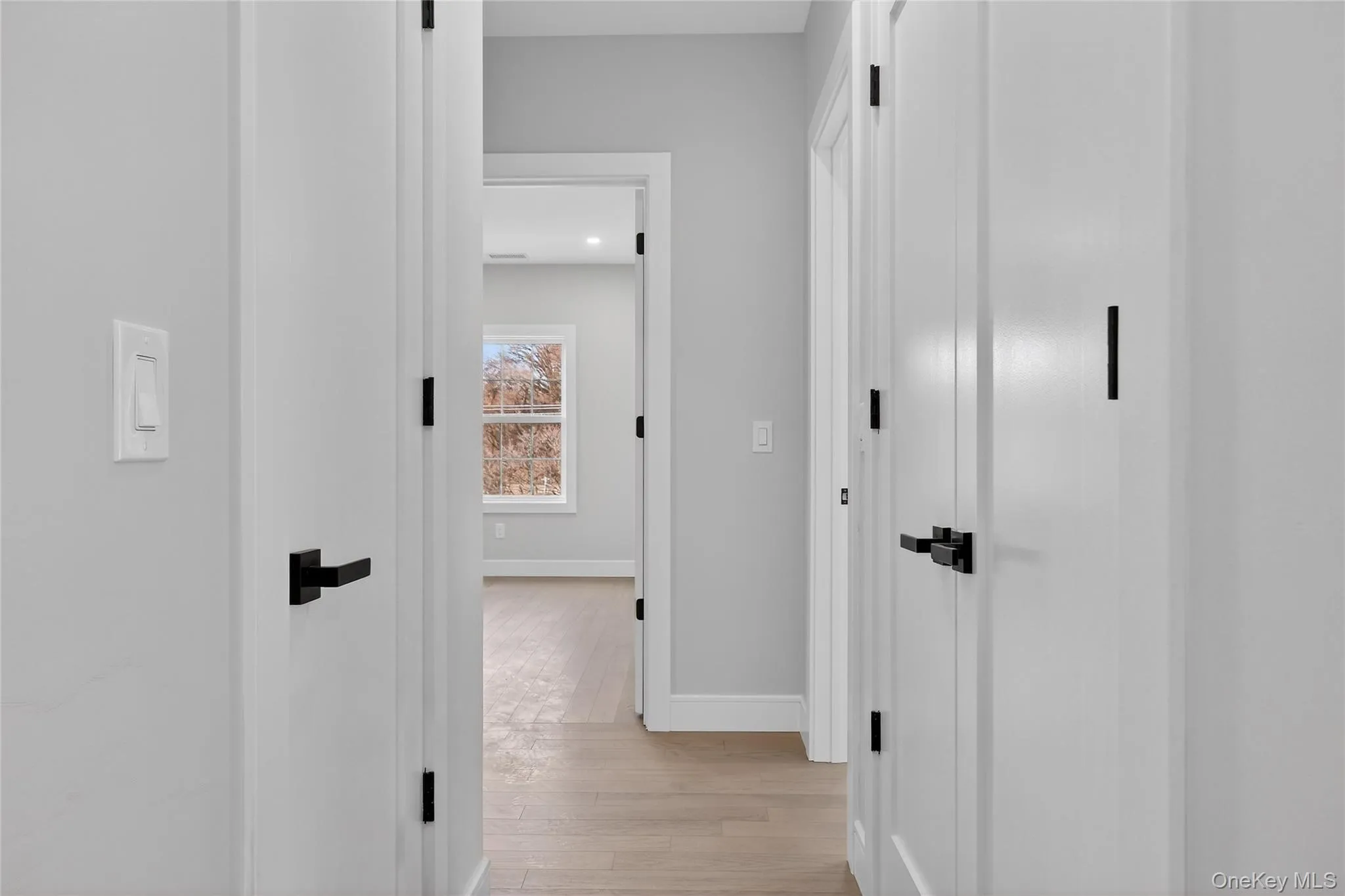 Hallway featuring light wood-style flooring and a barn door Hallway featuring light wood-style flooring and a barn door