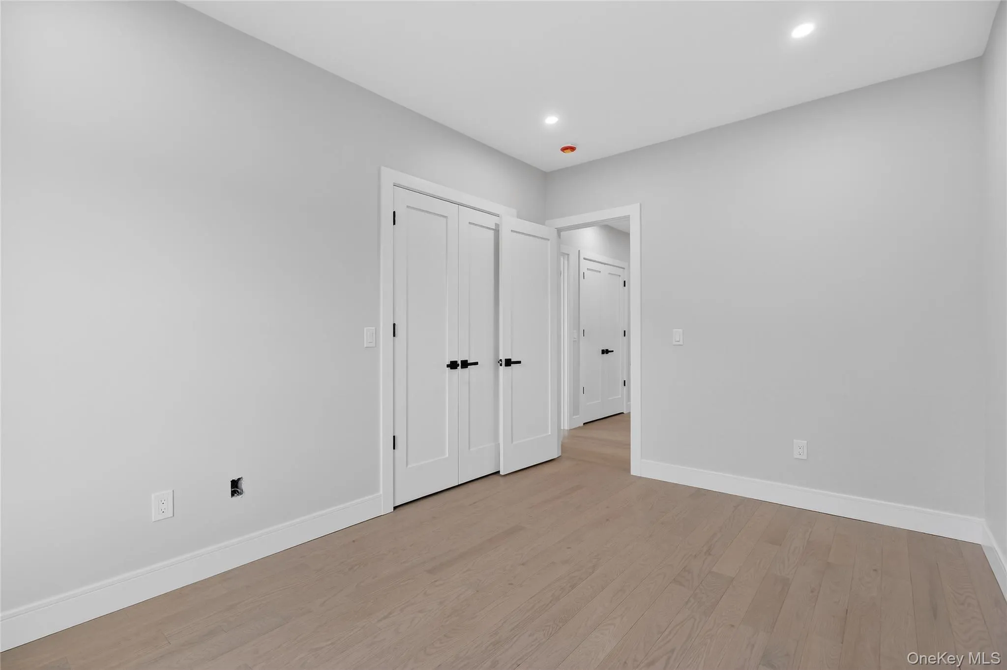 Unfurnished bedroom with light wood-type flooring, a closet, and recessed lighting Unfurnished bedroom with light wood-type flooring, a closet, and recessed lighting