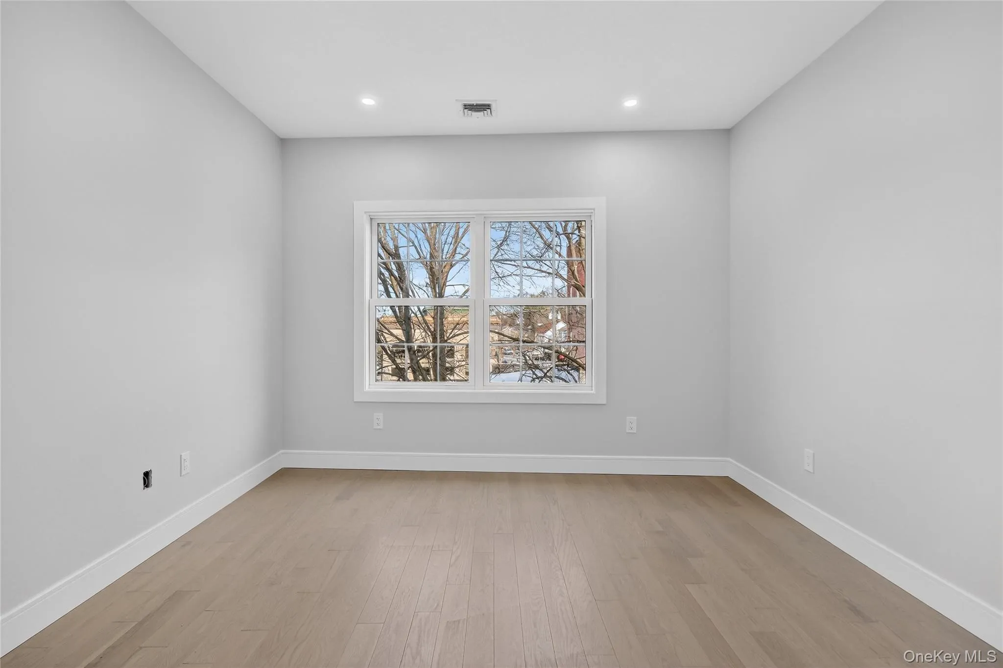 Unfurnished room with light wood-style floors and recessed lighting Unfurnished room with light wood-style floors and recessed lighting