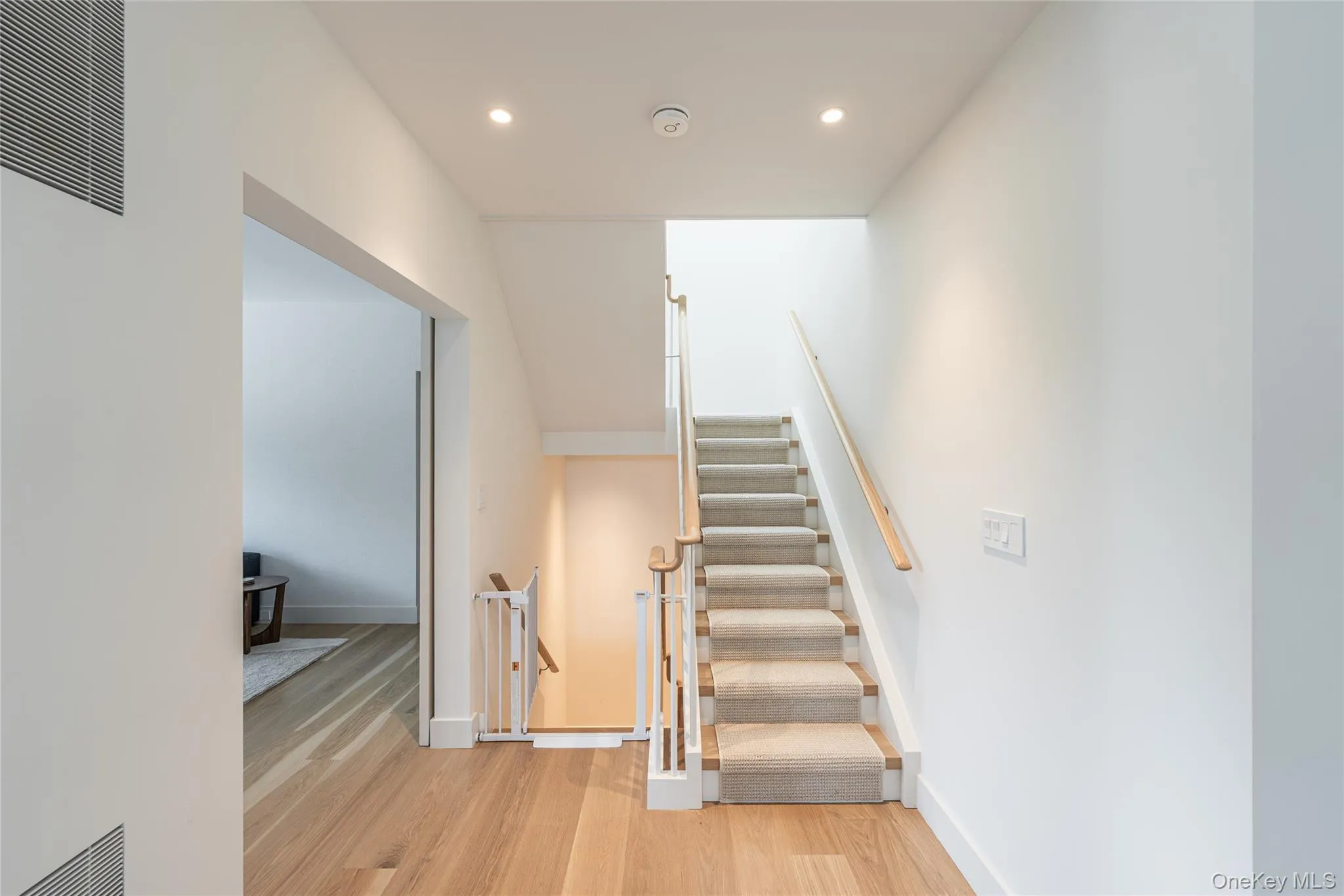 Stairs with a heating unit, wood finished floors, and recessed lighting Stairs with a heating unit, wood finished floors, and recessed lighting