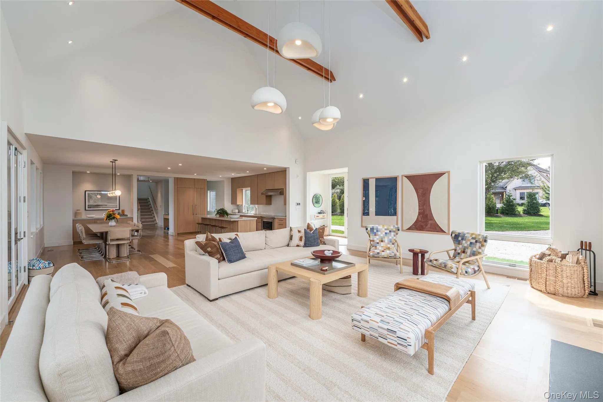 Living area with high vaulted ceiling, light wood-style flooring, beamed ceiling, recessed lighting, and stairway Living area with high vaulted ceiling, light wood-style flooring, beamed ceiling, recessed lighting, and stairway