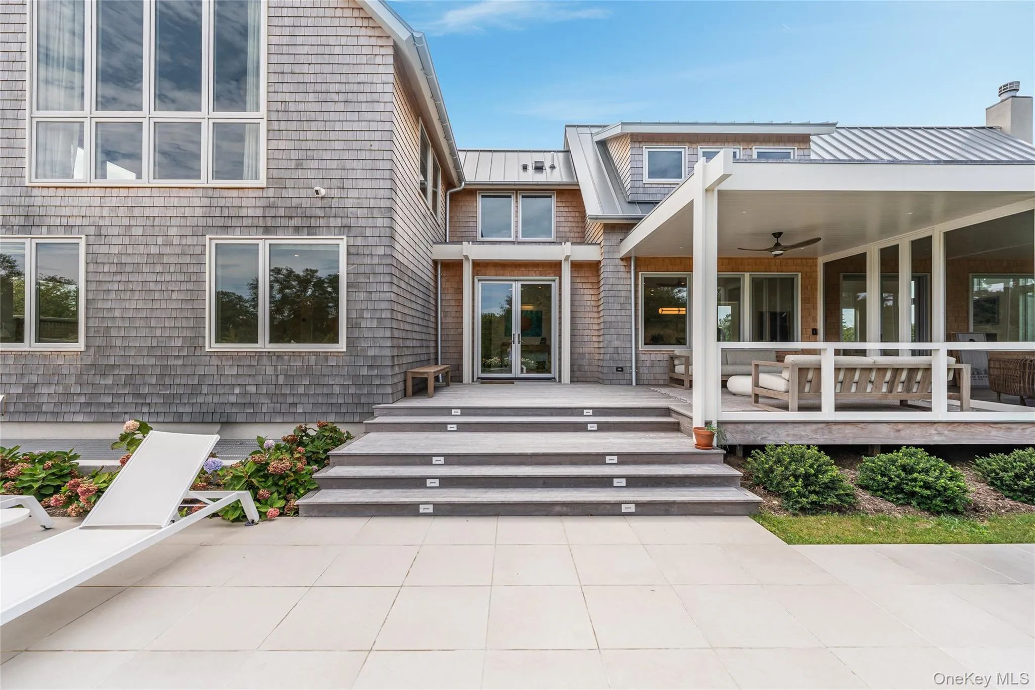 Doorway to property with a ceiling fan, a metal roof, a standing seam roof, and outdoor lounge area Doorway to property with a ceiling fan, a metal roof, a standing seam roof, and outdoor lounge area