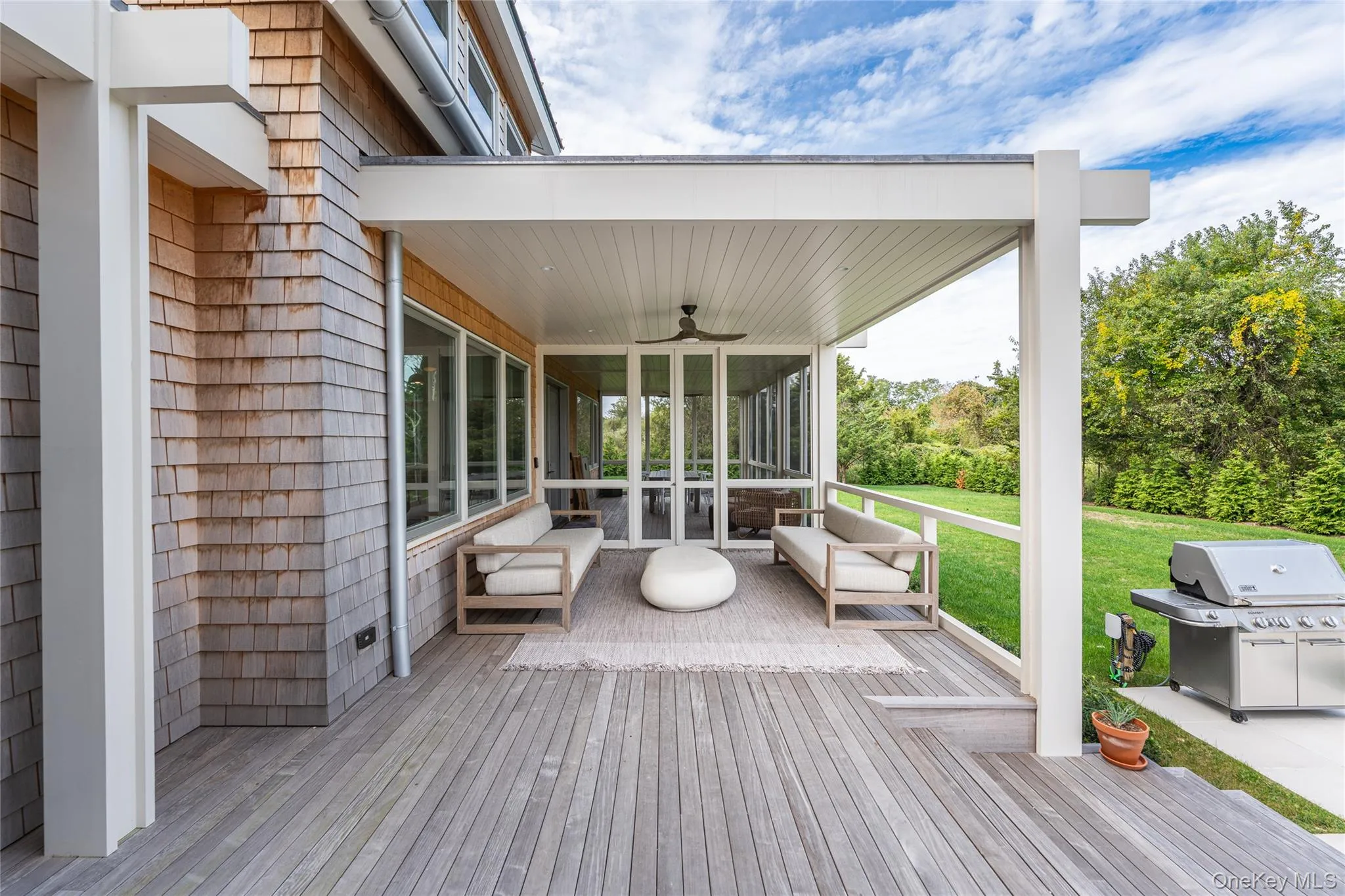 Wooden deck featuring ceiling fan, a sunroom, a grill, and a yard Wooden deck featuring ceiling fan, a sunroom, a grill, and a yard