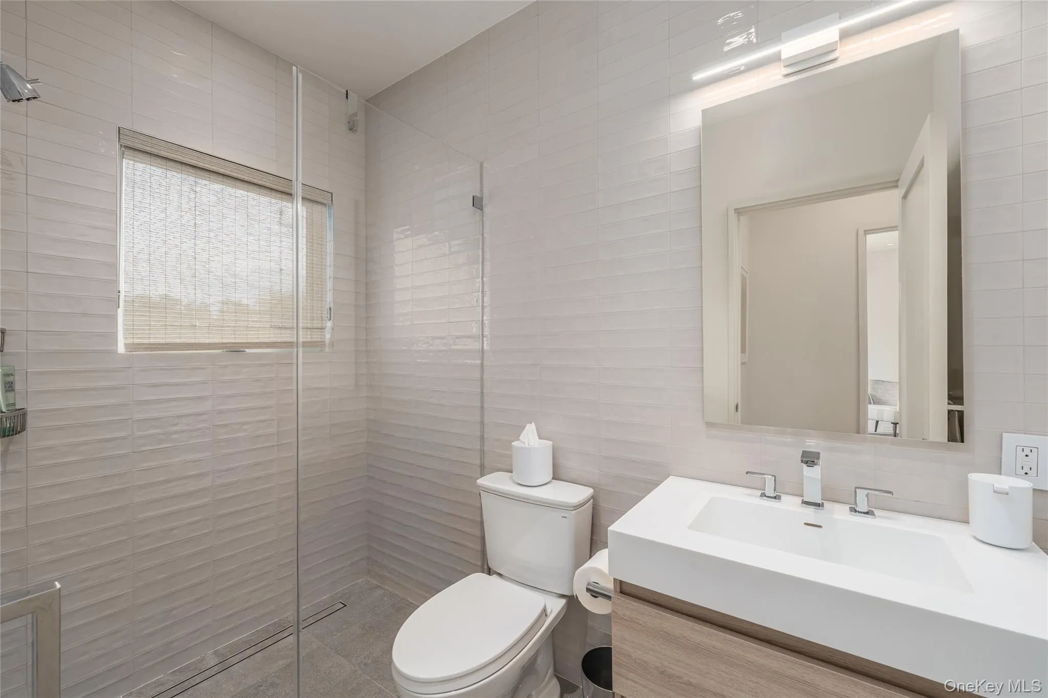 Full bath with a shower stall, vanity, and tile walls Full bath with a shower stall, vanity, and tile walls