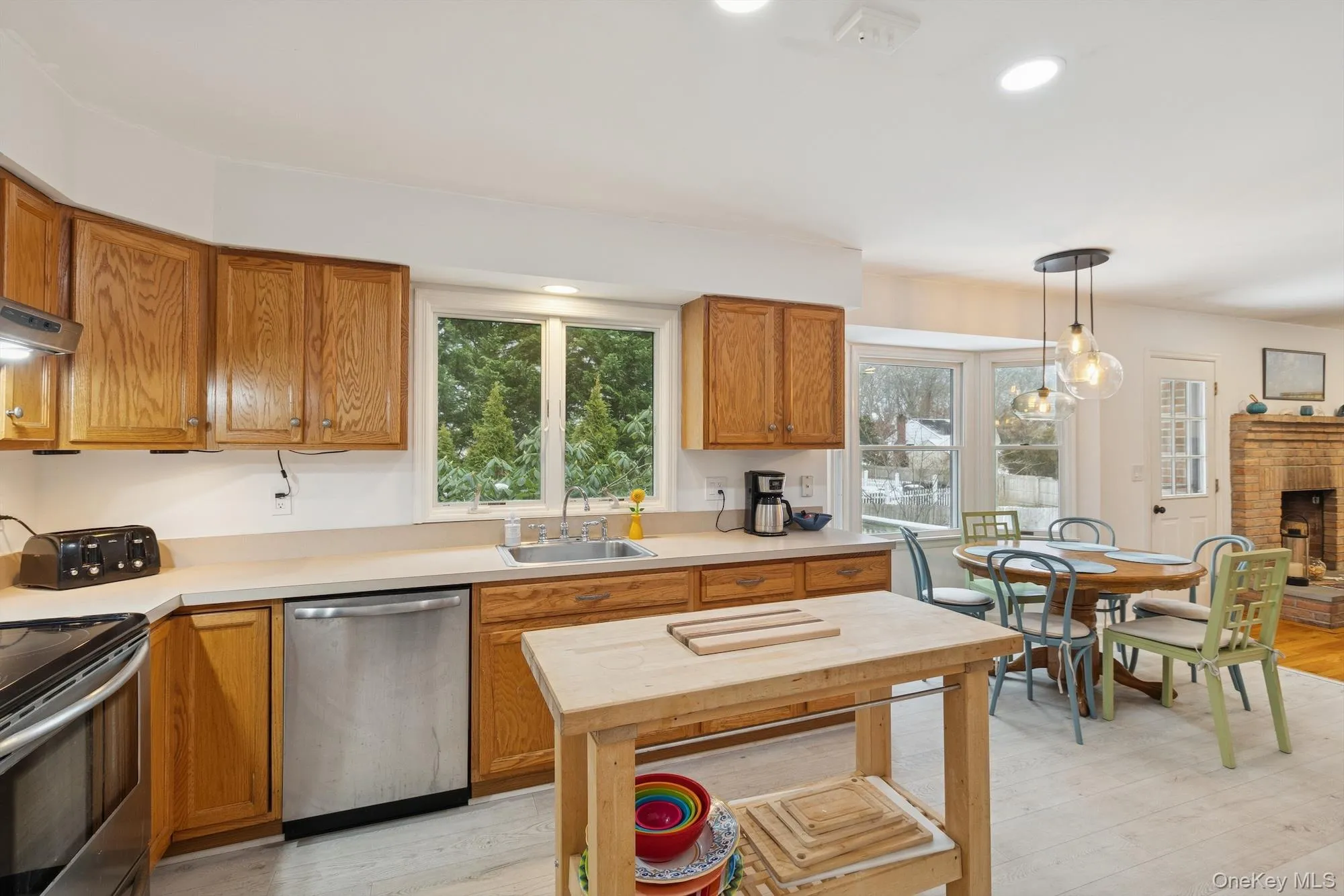 Kitchen featuring brown cabinets, stainless steel appliances, light countertops, recessed lighting, and light wood-type flooring Kitchen featuring brown cabinets, stainless steel appliances, light countertops, recessed lighting, and light wood-type flooring
