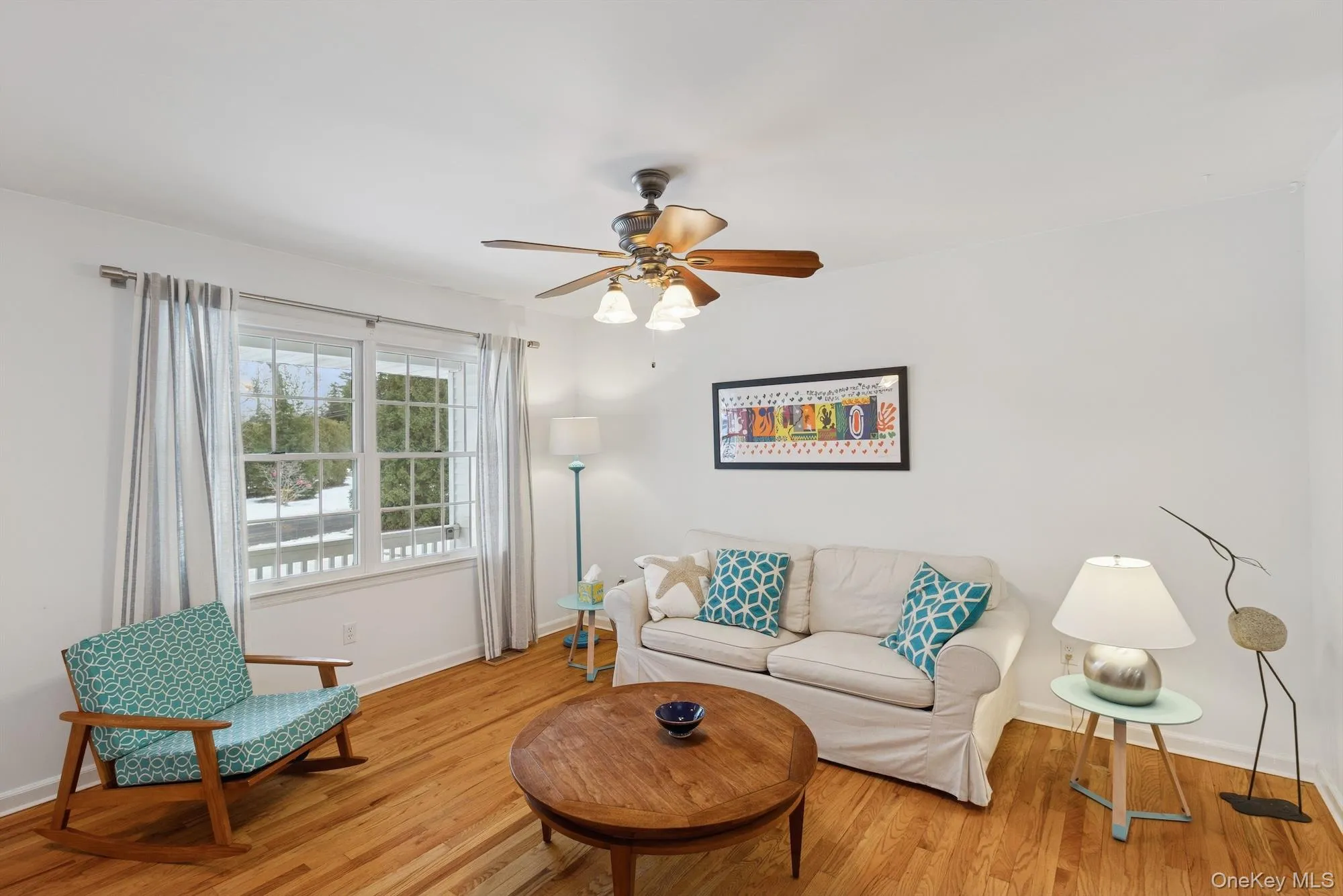 Living area featuring light wood finished floors and a ceiling fan Living area featuring light wood finished floors and a ceiling fan