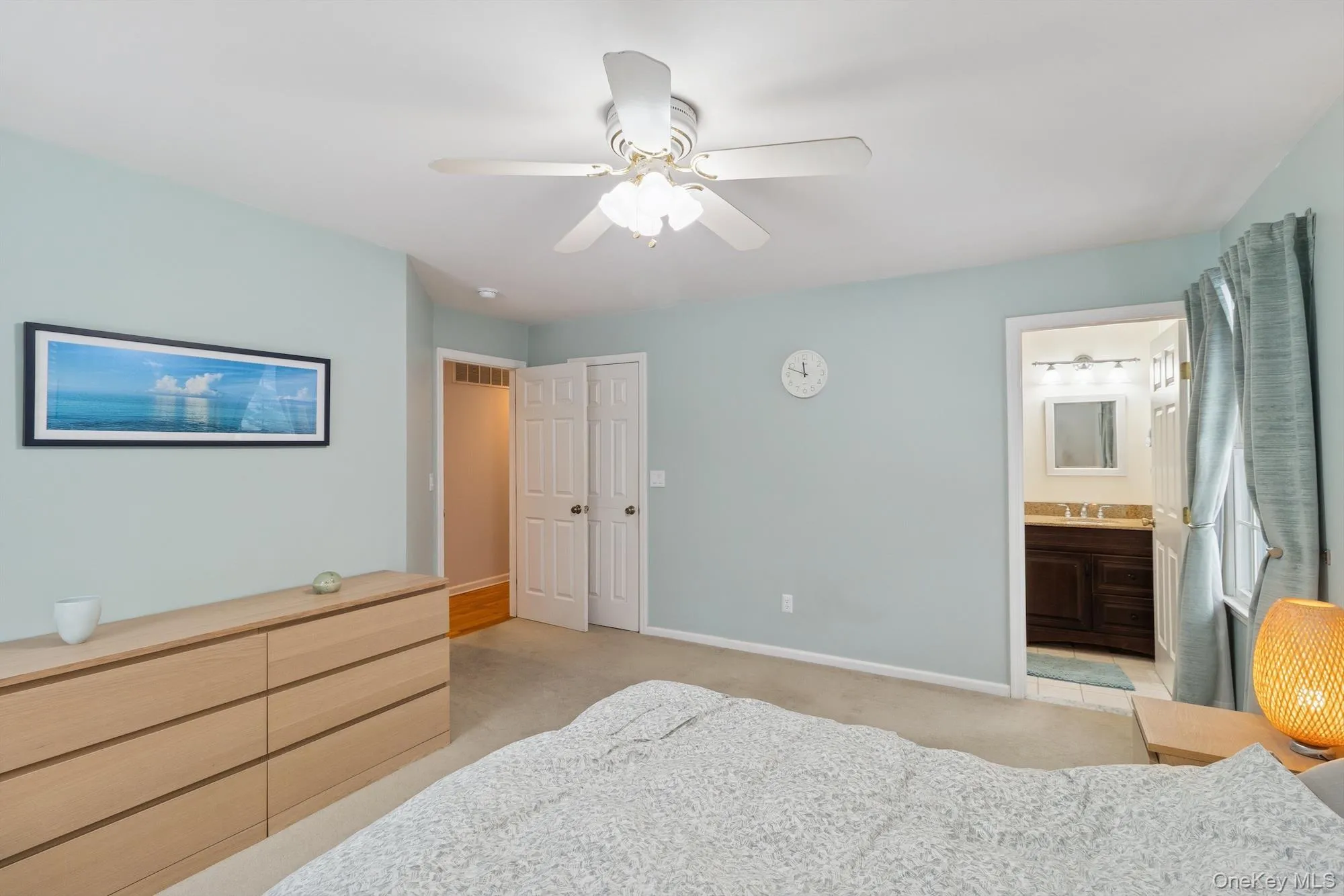 Bedroom featuring light colored carpet, ceiling fan, and connected bathroom Bedroom featuring light colored carpet, ceiling fan, and connected bathroom