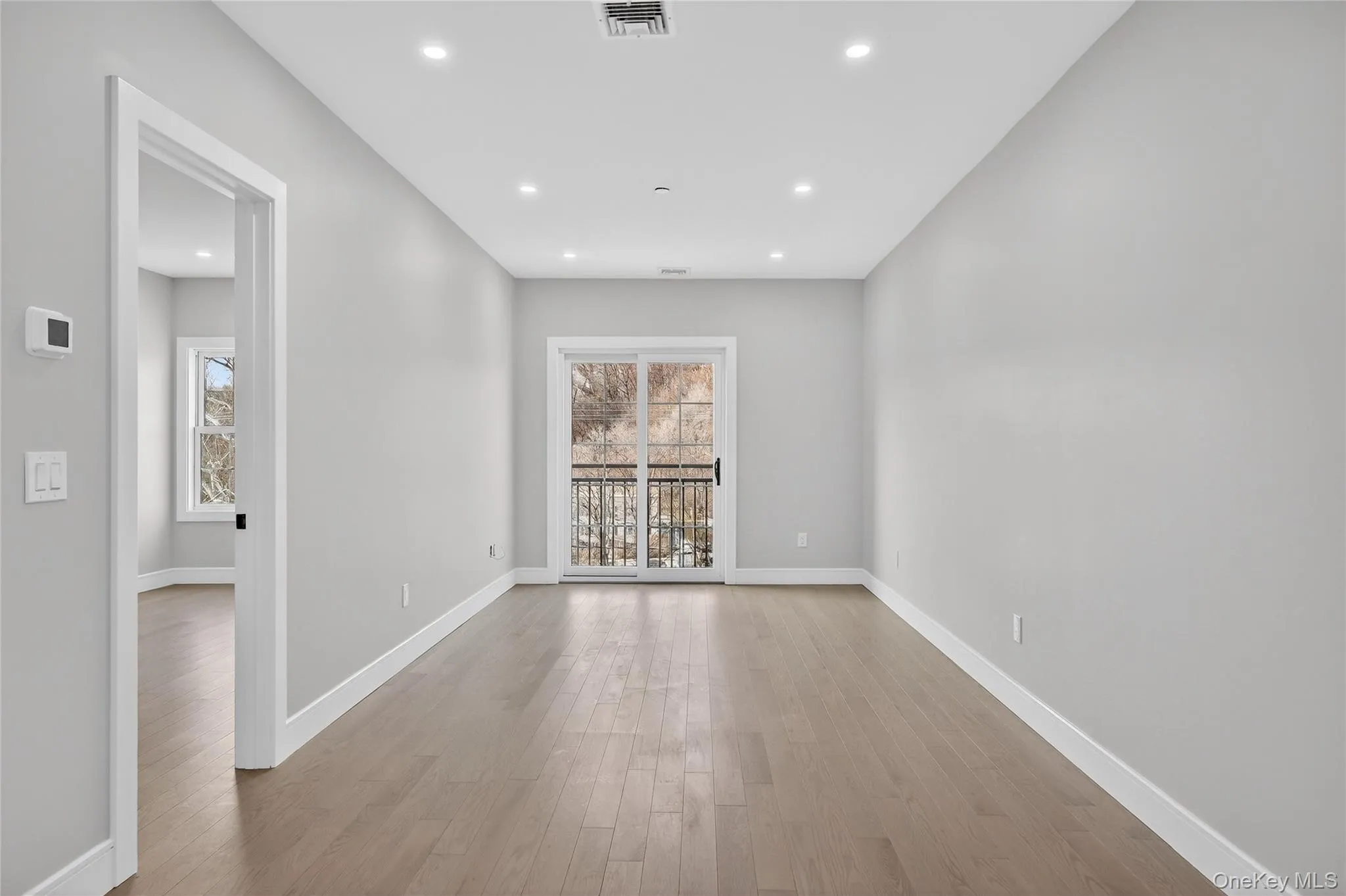 Empty room featuring light wood-style floors, plenty of natural light, and recessed lighting Empty room featuring light wood-style floors, plenty of natural light, and recessed lighting