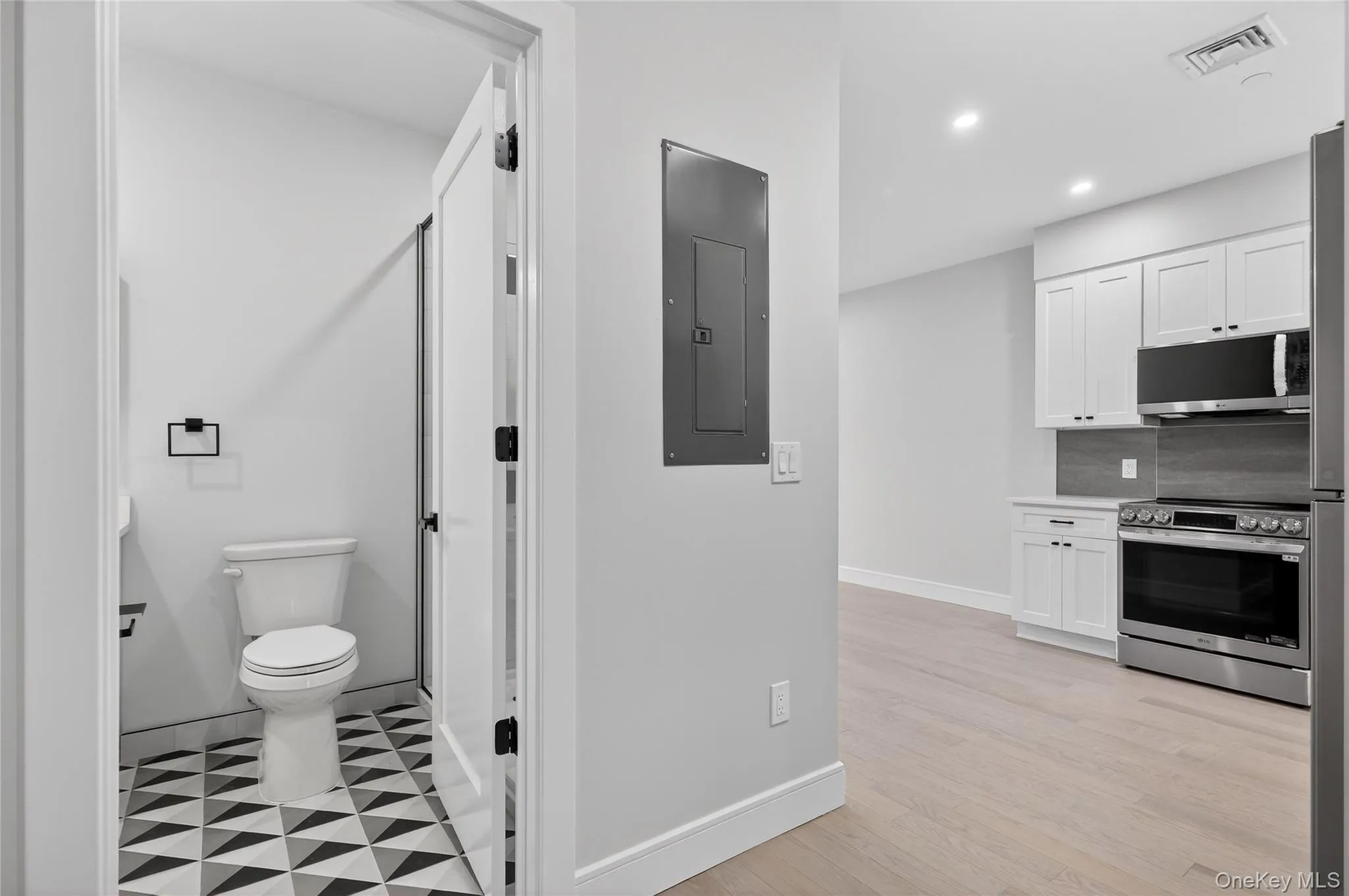 Full bath featuring electric panel, light flooring, recessed lighting, and a stall shower Full bath featuring electric panel, light flooring, recessed lighting, and a stall shower