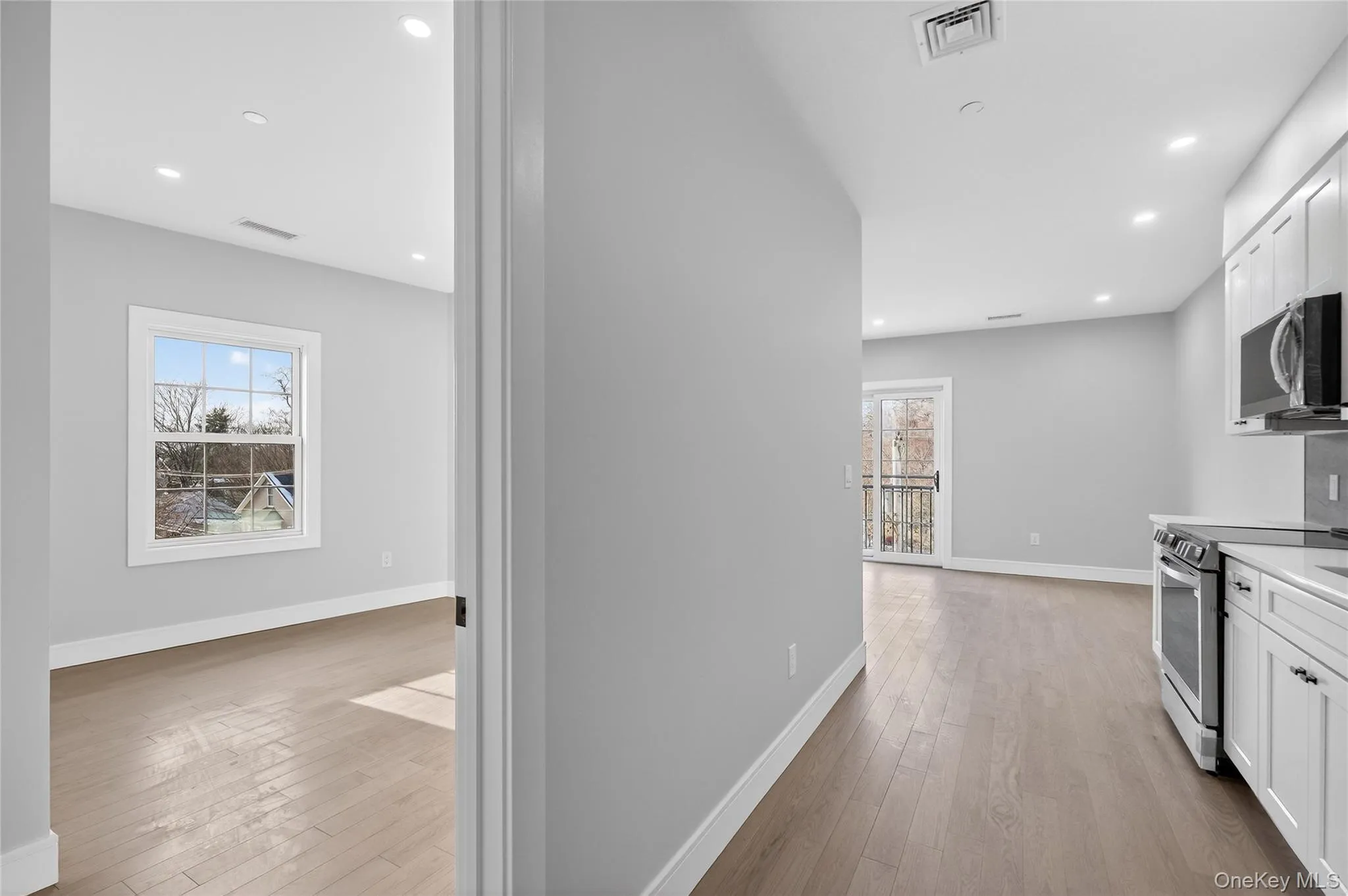 Kitchen with appliances with stainless steel finishes, plenty of natural light, light wood-style floors, and recessed lighting Kitchen with appliances with stainless steel finishes, plenty of natural light, light wood-style floors, and recessed lighting