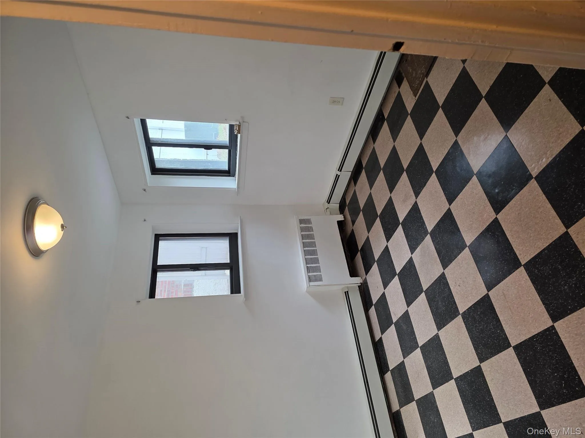 Spare room with a baseboard heating unit, radiator, and dark floors Spare room with a baseboard heating unit, radiator, and dark floors