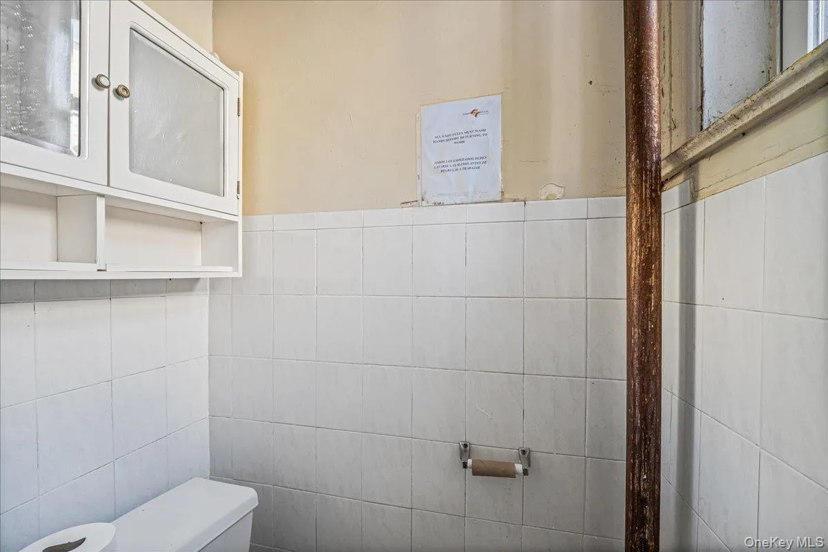 Half bath with toilet and tile walls Half bath with toilet and tile walls