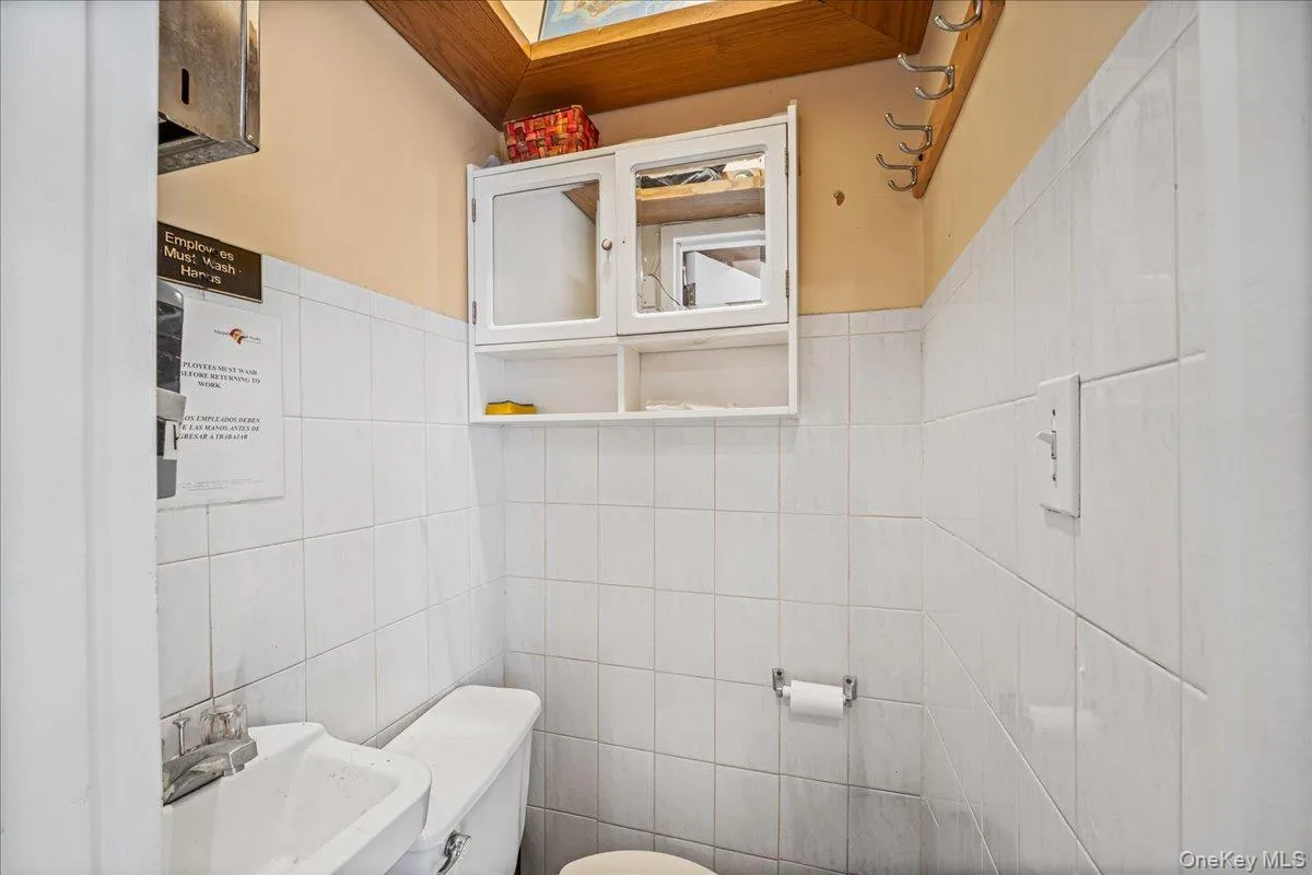 Half bathroom with tile walls and a skylight Half bathroom with tile walls and a skylight