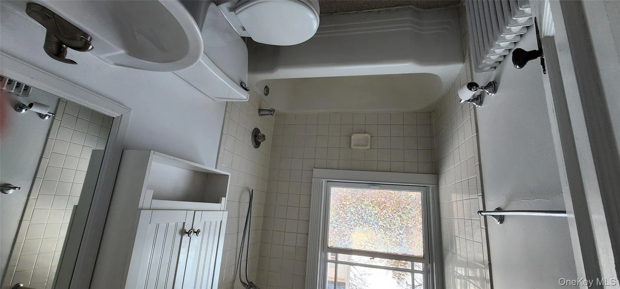 Bathroom with radiator heating unit and tub / shower combination Bathroom with radiator heating unit and tub / shower combination