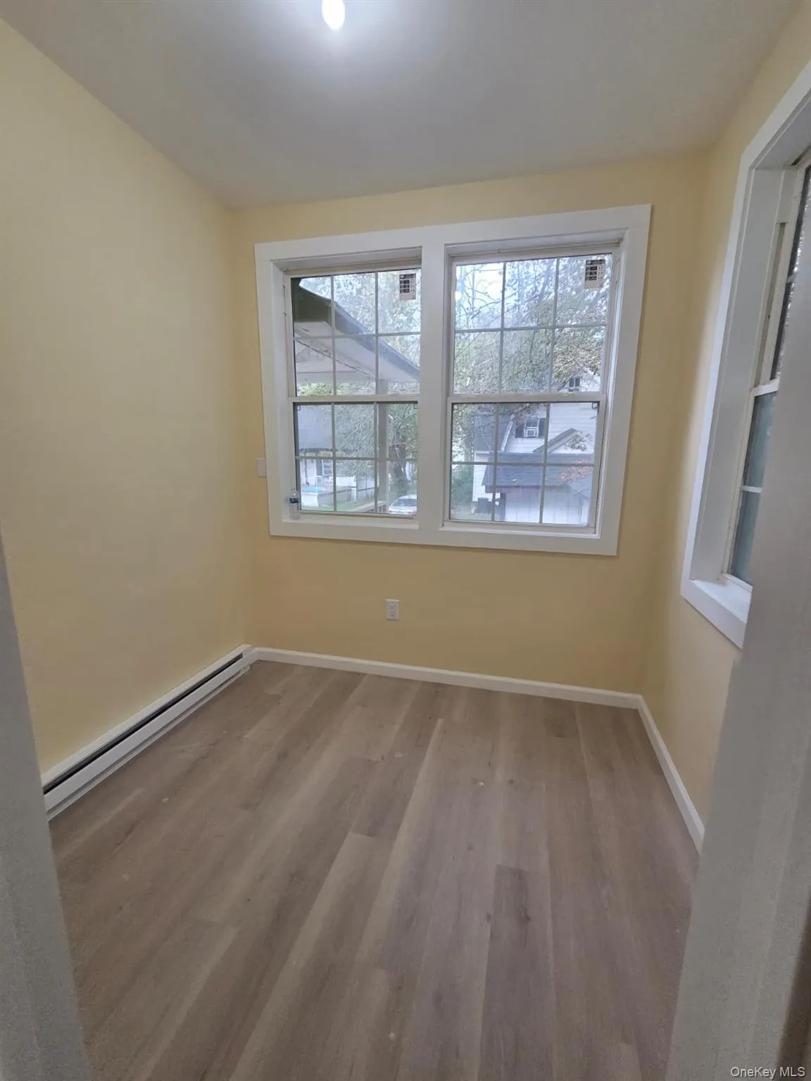Empty room featuring a baseboard radiator and light wood-style flooring Empty room featuring a baseboard radiator and light wood-style flooring