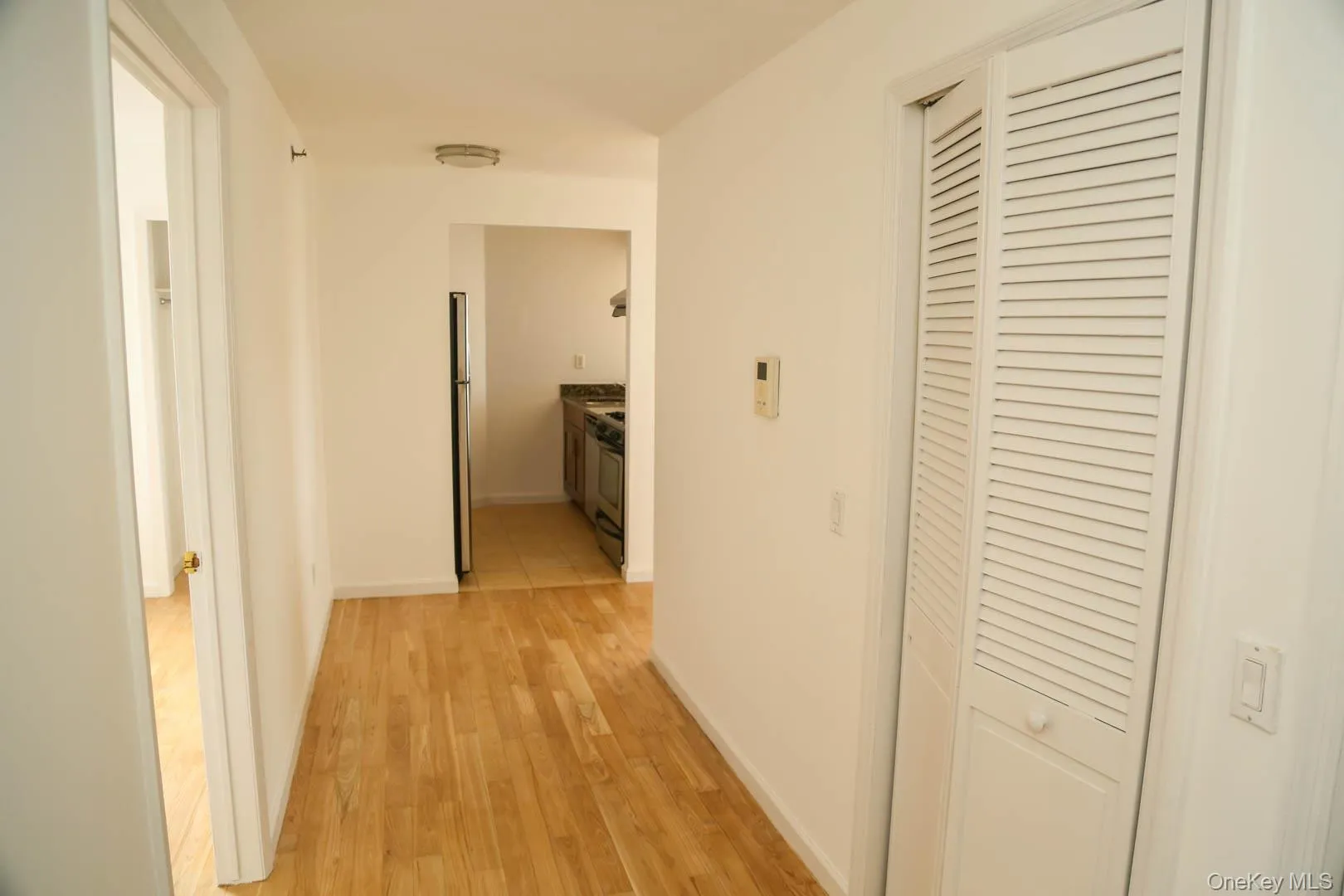 Hallway featuring light wood-style floors and baseboards Hallway featuring light wood-style floors and baseboards