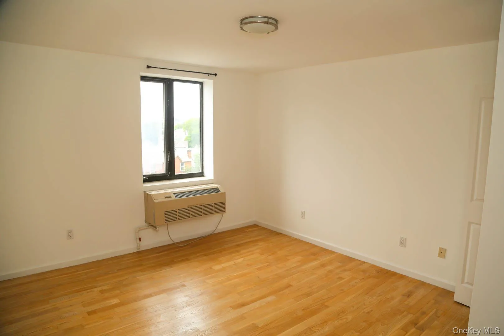 Unfurnished room featuring light wood finished floors and a wall unit AC Unfurnished room featuring light wood finished floors and a wall unit AC
