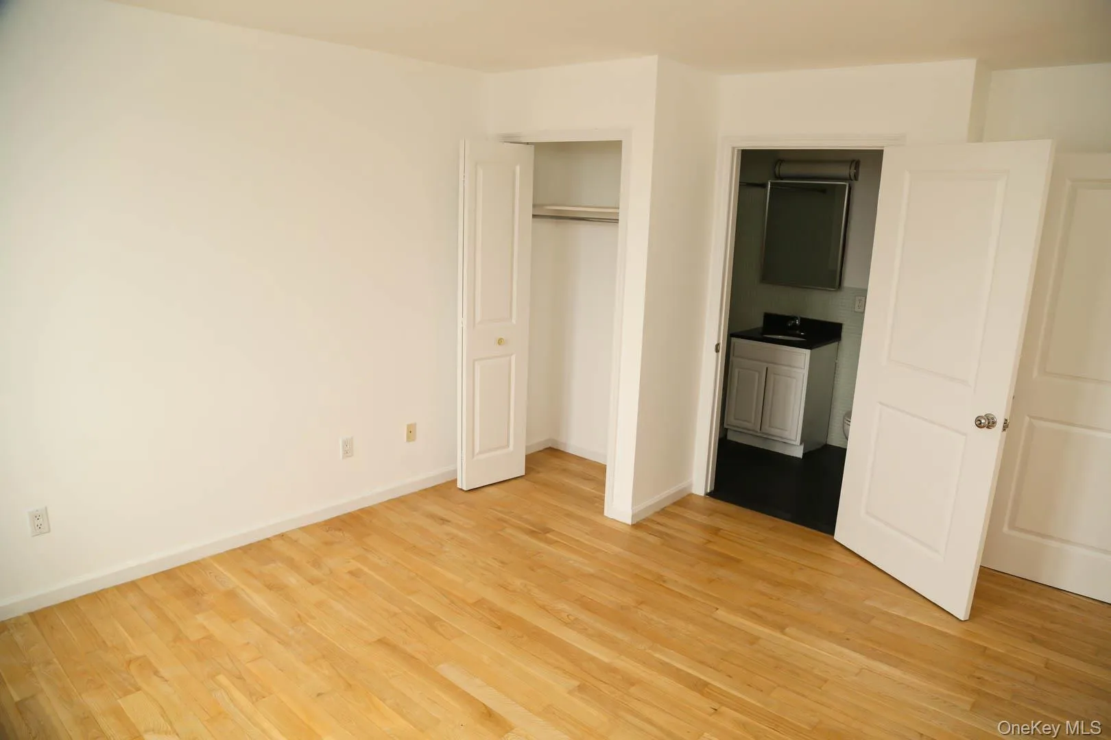 Unfurnished bedroom with a closet and light wood finished floors Unfurnished bedroom with a closet and light wood finished floors