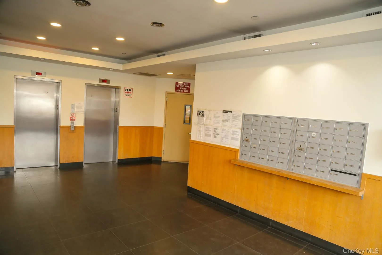 Building lobby featuring a wainscoted wall, recessed lighting, and wooden walls Building lobby featuring a wainscoted wall, recessed lighting, and wooden walls