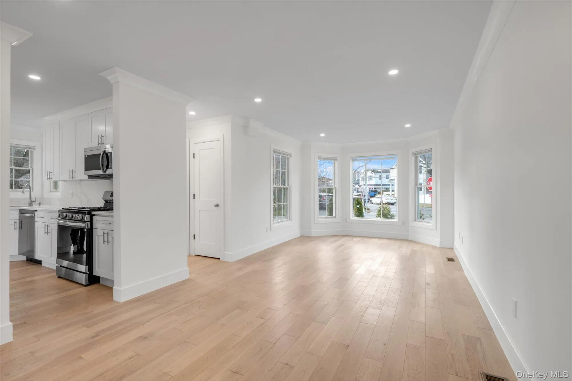 Unfurnished living room featuring light wood finished floors, crown molding, and recessed lighting Unfurnished living room featuring light wood finished floors, crown molding, and recessed lighting