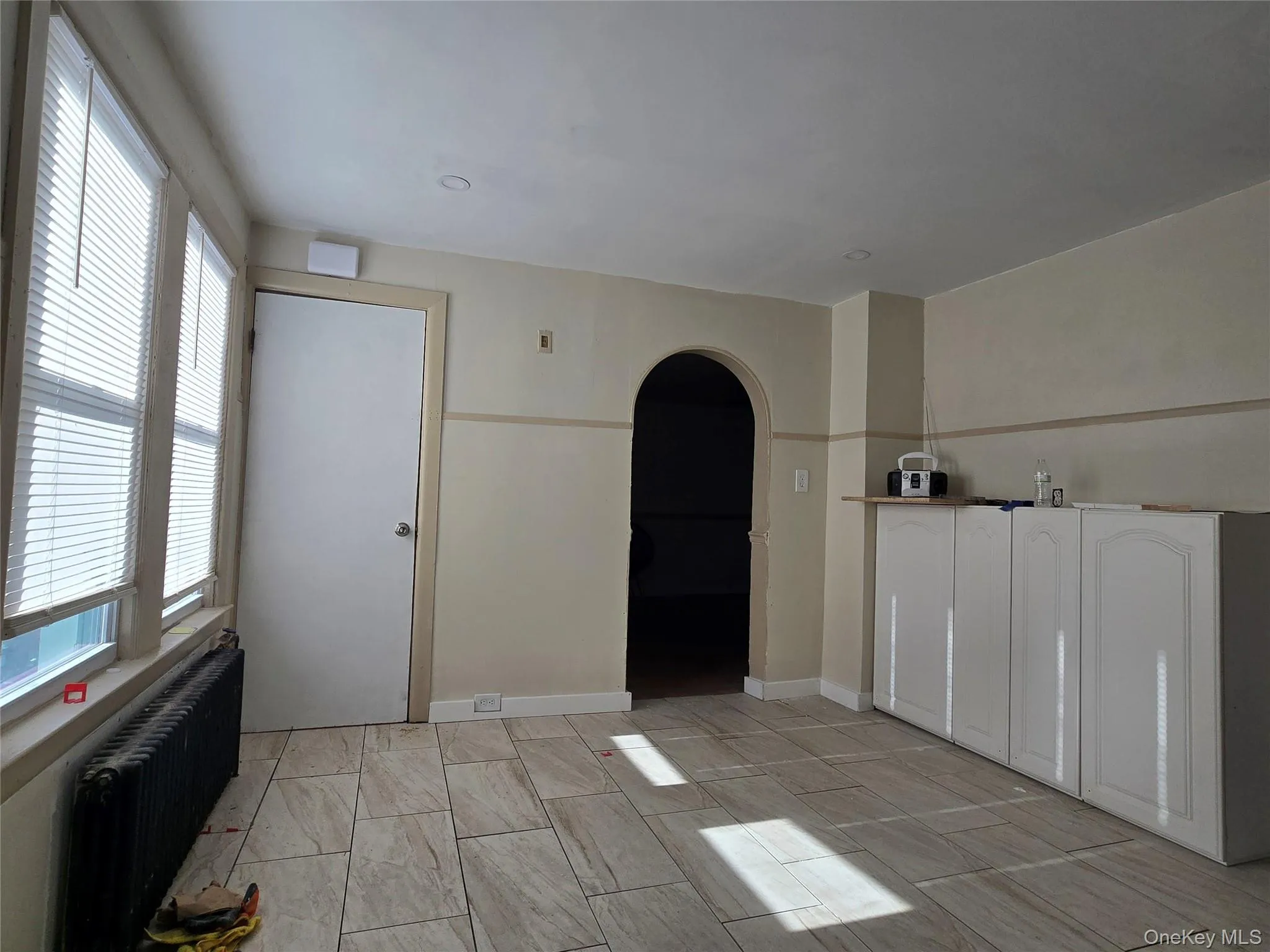 Spare room with arched walkways and radiator heating unit Spare room with arched walkways and radiator heating unit