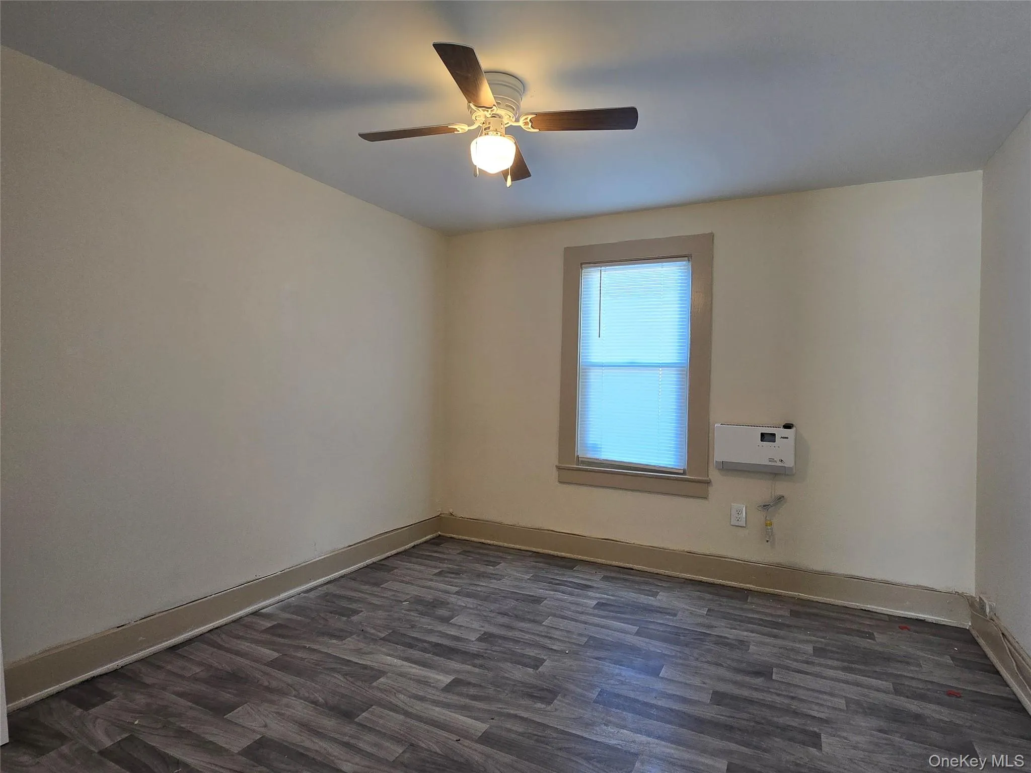 Unfurnished room featuring dark wood finished floors and ceiling fan Unfurnished room featuring dark wood finished floors and ceiling fan