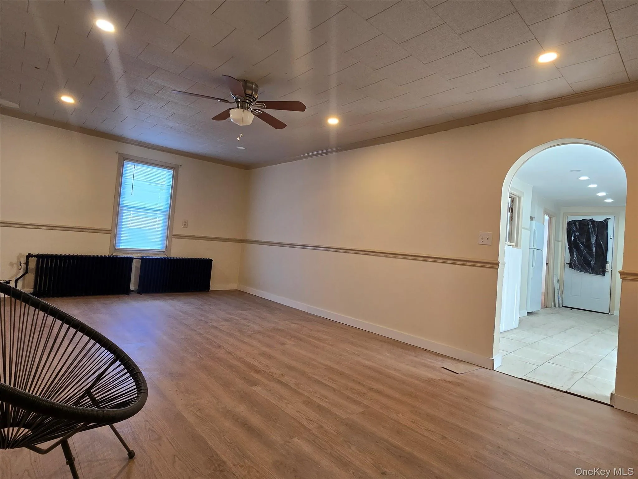 Spare room featuring arched walkways, light wood finished floors, ornamental molding, ceiling fan, and recessed lighting Spare room featuring arched walkways, light wood finished floors, ornamental molding, ceiling fan, and recessed lighting