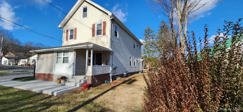 Back of house featuring a yard and a porch Back of house featuring a yard and a porch
