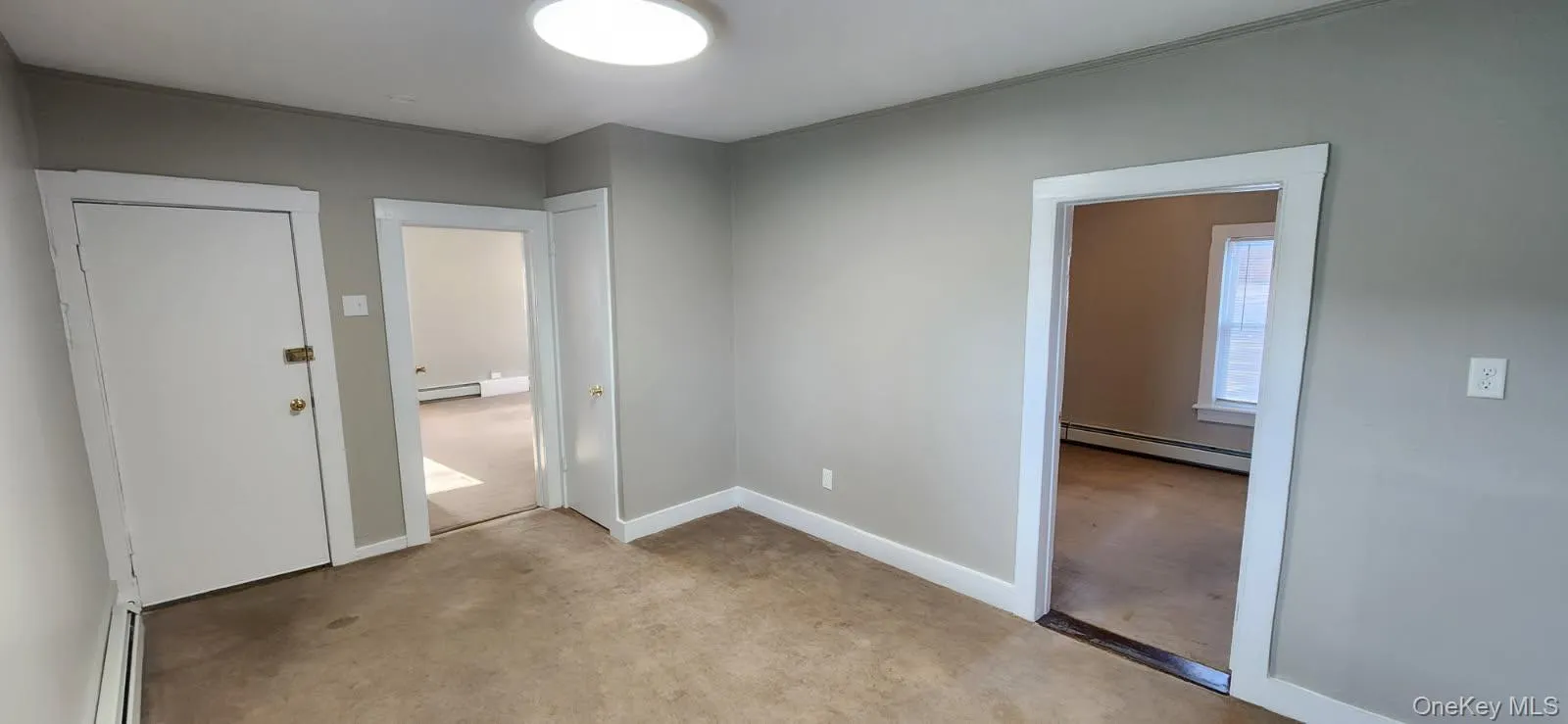 Unfurnished bedroom with baseboard heating and a baseboard radiator Unfurnished bedroom with baseboard heating and a baseboard radiator