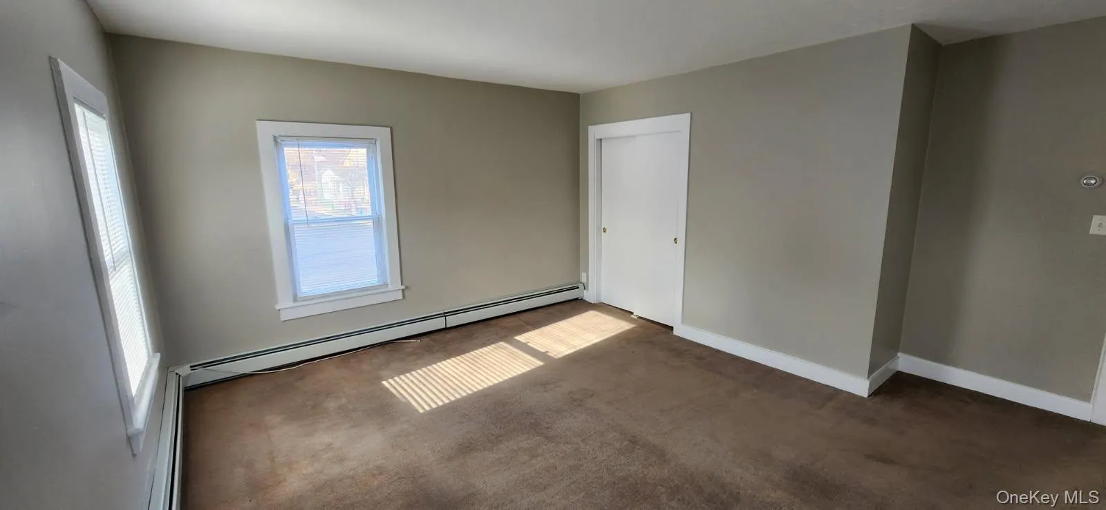 Spare room with a baseboard radiator, carpet floors, and baseboard heating Spare room with a baseboard radiator, carpet floors, and baseboard heating