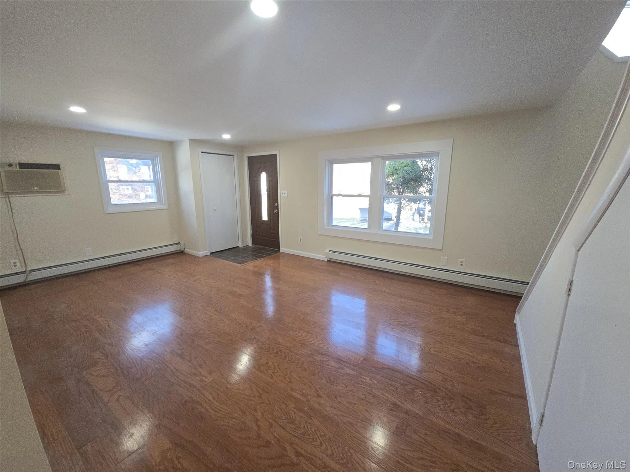 Entryway with wood finished floors, baseboard heating, recessed lighting, and a wall mounted AC Entryway with wood finished floors, baseboard heating, recessed lighting, and a wall mounted AC