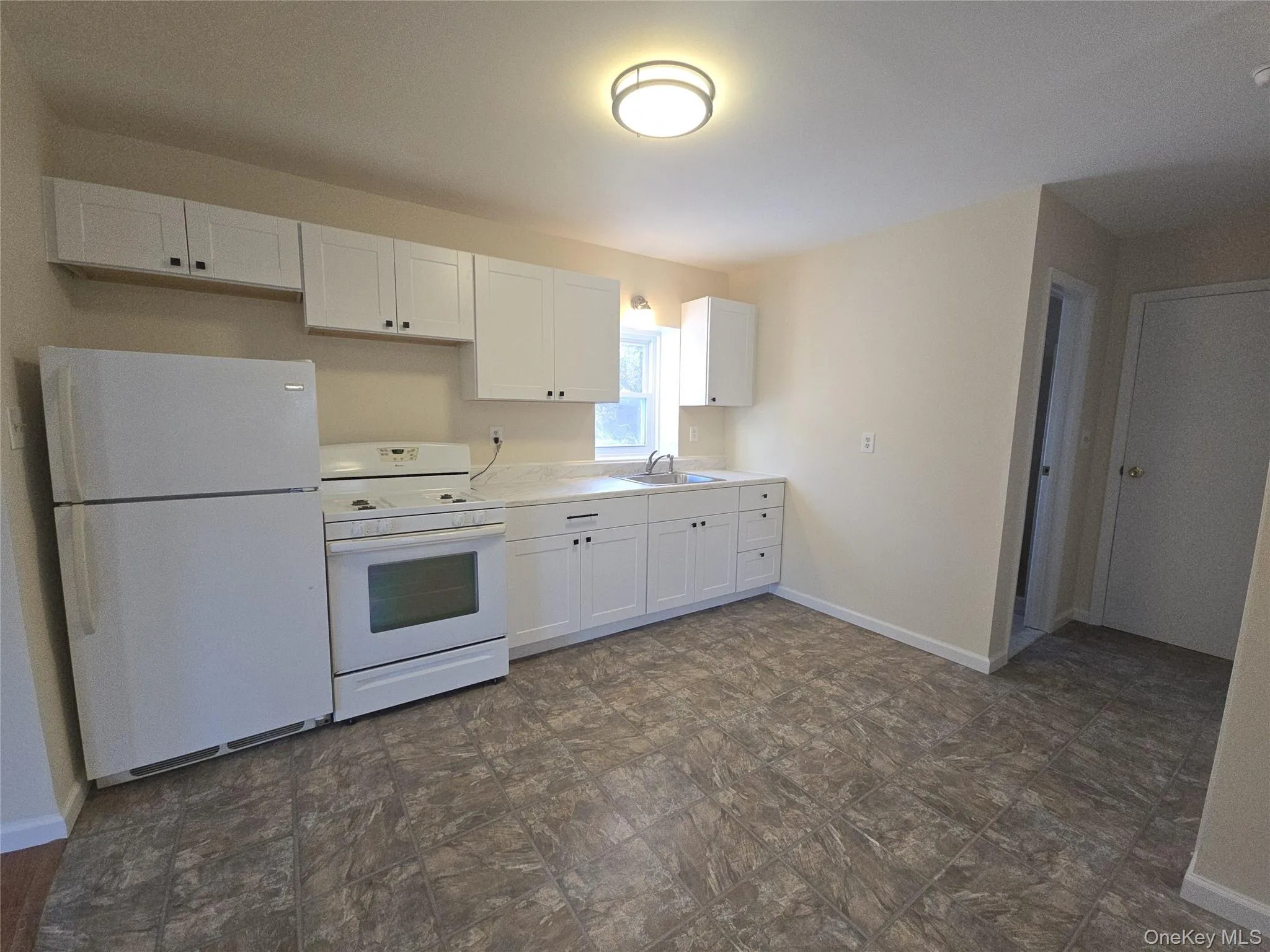 Kitchen with white appliances, white cabinets, and light countertops Kitchen with white appliances, white cabinets, and light countertops