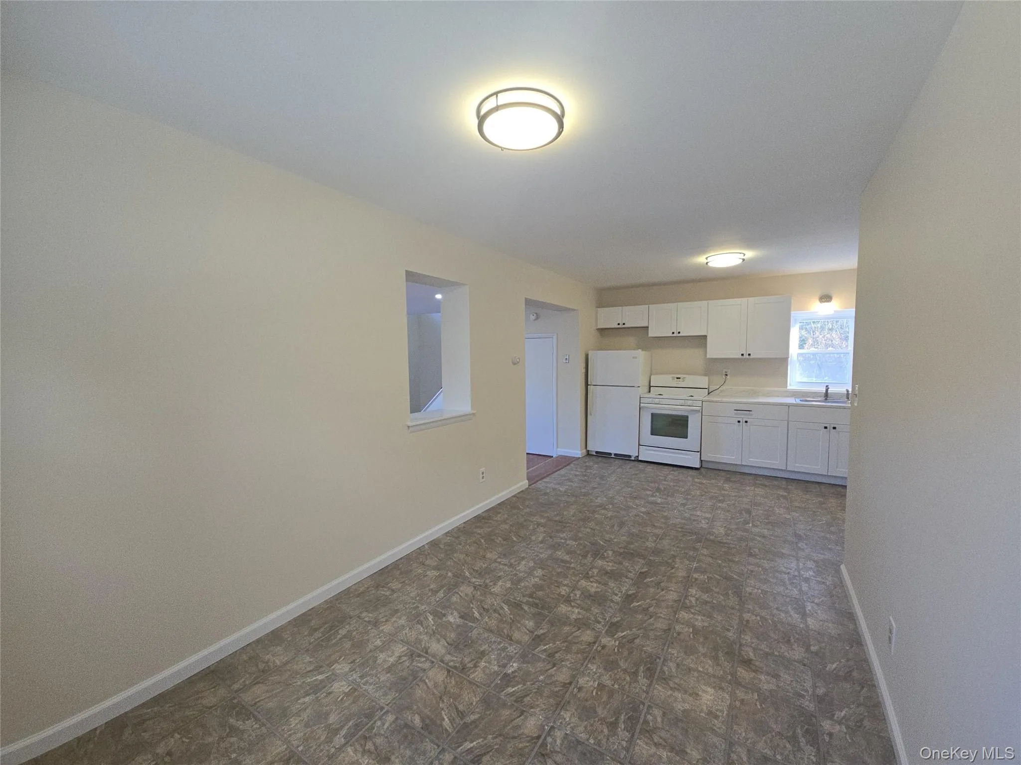 Unfurnished living room featuring baseboards and a sink Unfurnished living room featuring baseboards and a sink