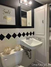 Bathroom featuring toilet and a sink Bathroom featuring toilet and a sink