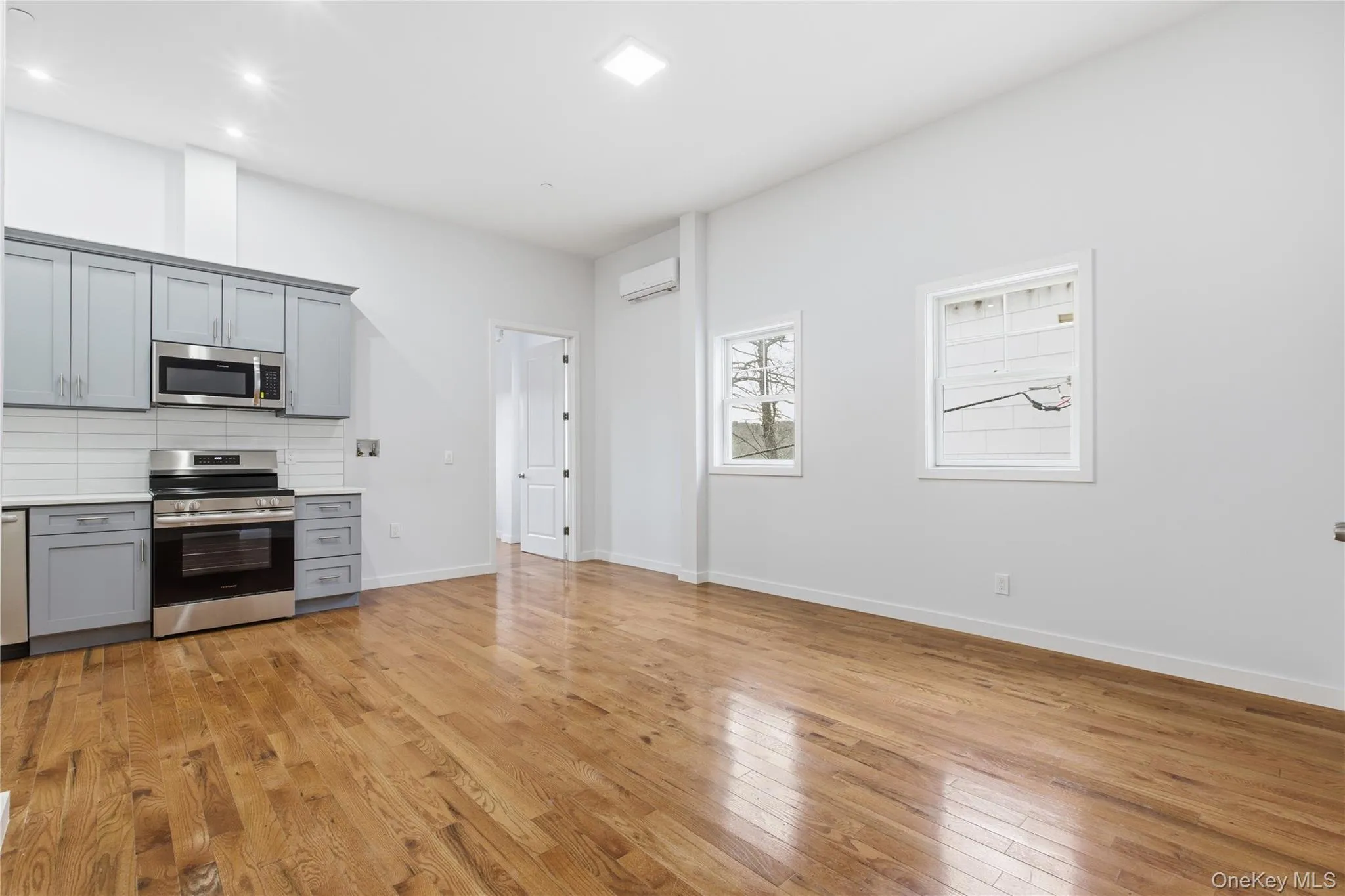 Open Kitchen and Living Room with gray cabinets, stainless steel appliances, hardwood floors Open Kitchen and Living Room with gray cabinets, stainless steel appliances, hardwood floors