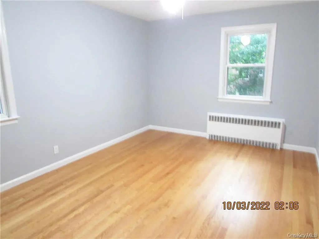 Spare room with radiator heating unit and wood finished floors Spare room with radiator heating unit and wood finished floors