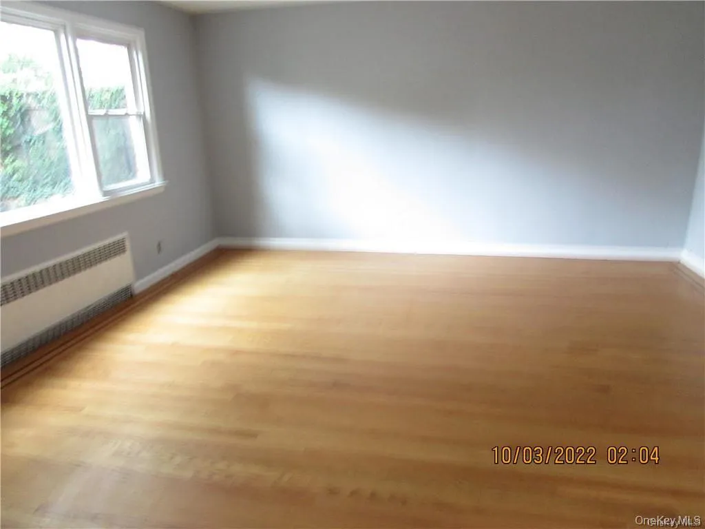 Empty room featuring radiator and light wood-style flooring Empty room featuring radiator and light wood-style flooring