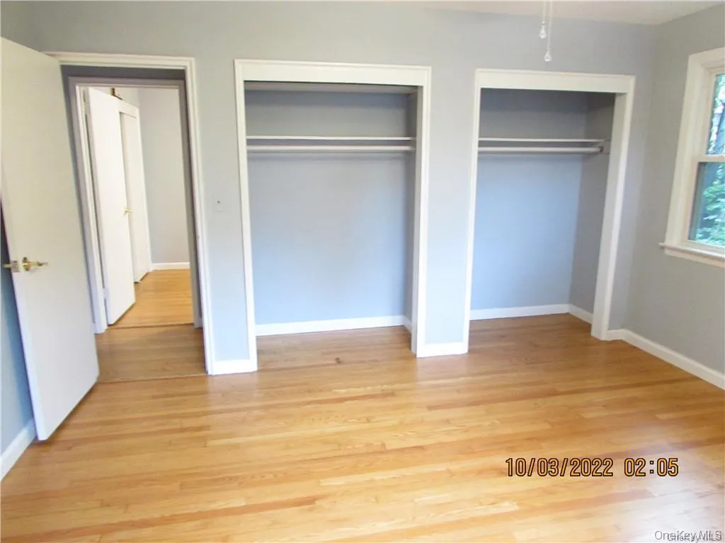 Unfurnished bedroom with multiple closets, light wood finished floors, and a ceiling fan Unfurnished bedroom with multiple closets, light wood finished floors, and a ceiling fan