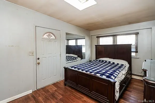 Bedroom featuring dark wood-style floors and baseboard heating Bedroom featuring dark wood-style floors and baseboard heating