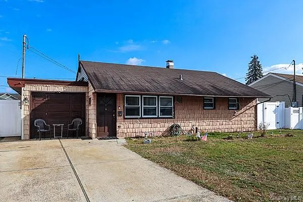 View of front of home featuring an attached garage, driveway, and a gate View of front of home featuring an attached garage, driveway, and a gate