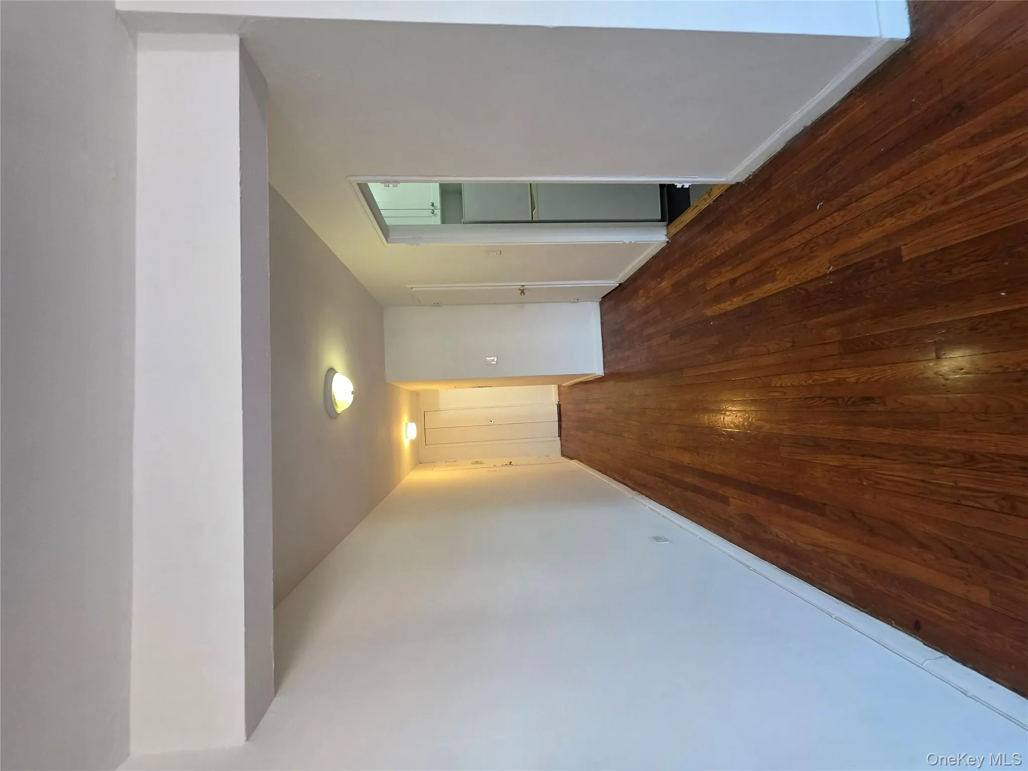 Corridor featuring dark wood-style flooring and baseboards Corridor featuring dark wood-style flooring and baseboards