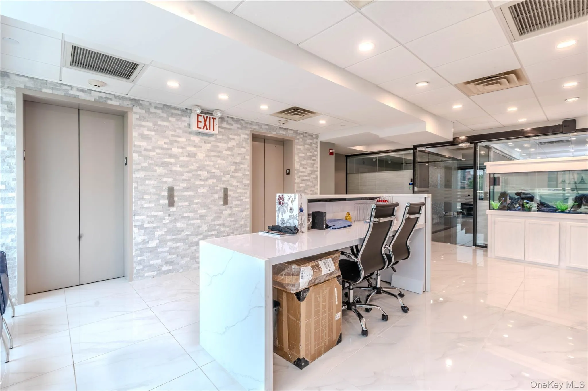 Office space featuring elevator, recessed lighting, and a paneled ceiling Office space featuring elevator, recessed lighting, and a paneled ceiling