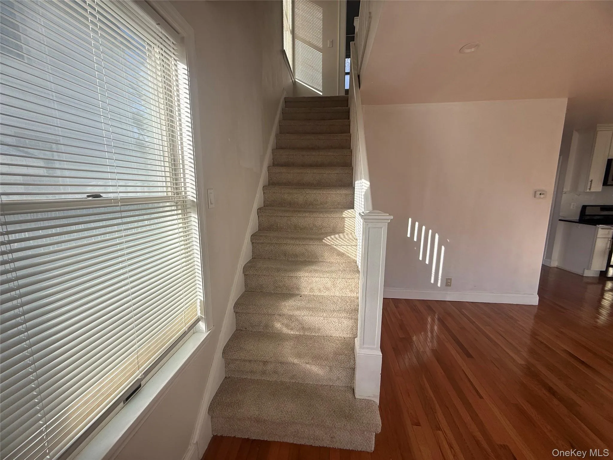 Staircase featuring wood-type flooring and baseboards Staircase featuring wood-type flooring and baseboards