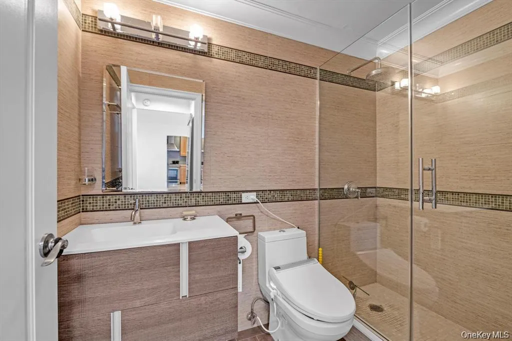 Full bath with vanity, a shower stall, and tile walls Full bath with vanity, a shower stall, and tile walls