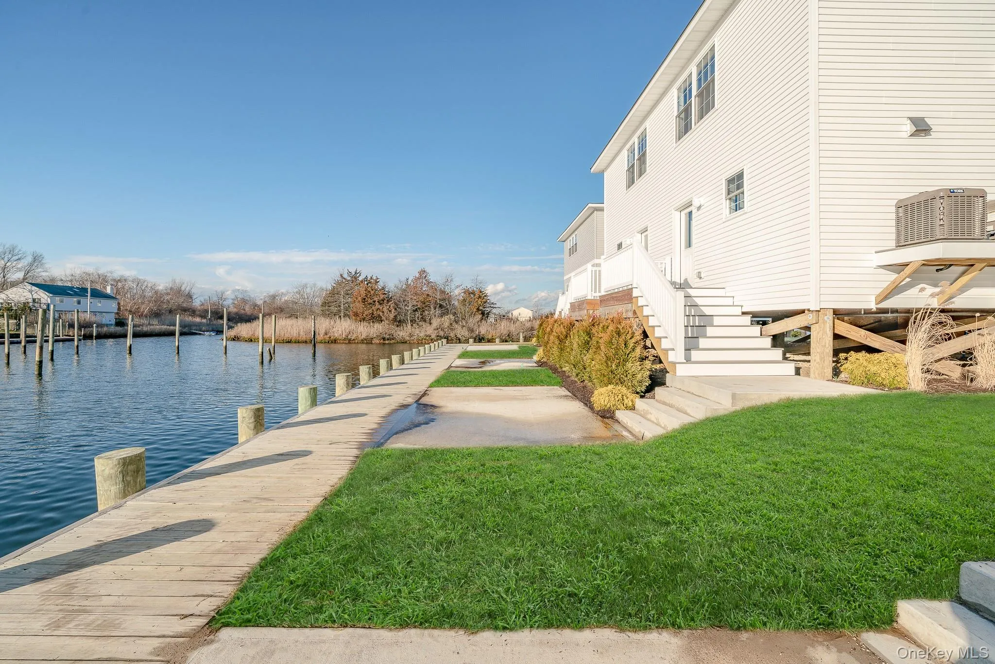 Dock area with stairway, a water view, and a lawn Dock area with stairway, a water view, and a lawn
