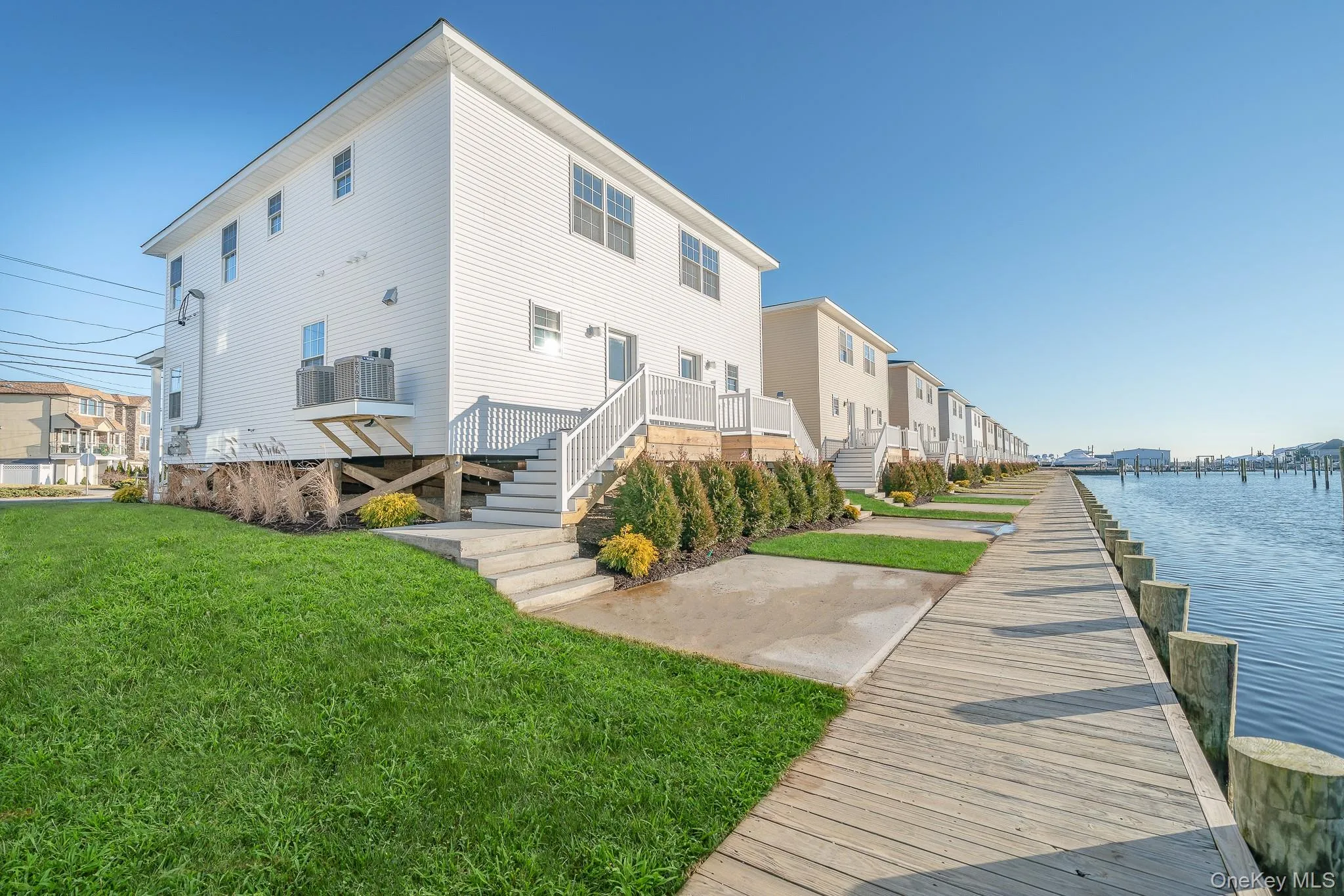 Rear view of house featuring a lawn, stairs, and a water view Rear view of house featuring a lawn, stairs, and a water view