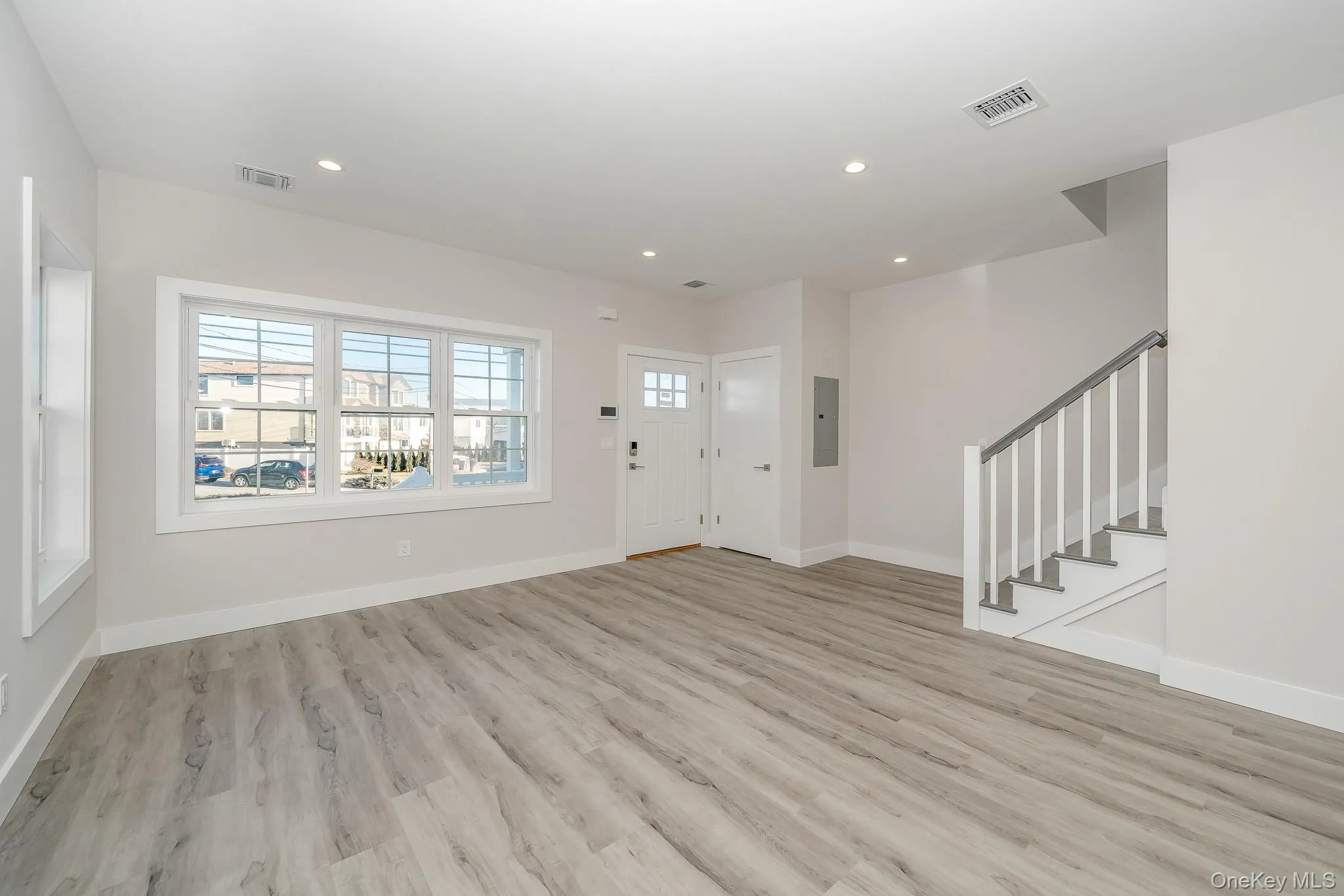 Entryway with stairway, light wood-style floors, recessed lighting, and electric panel Entryway with stairway, light wood-style floors, recessed lighting, and electric panel
