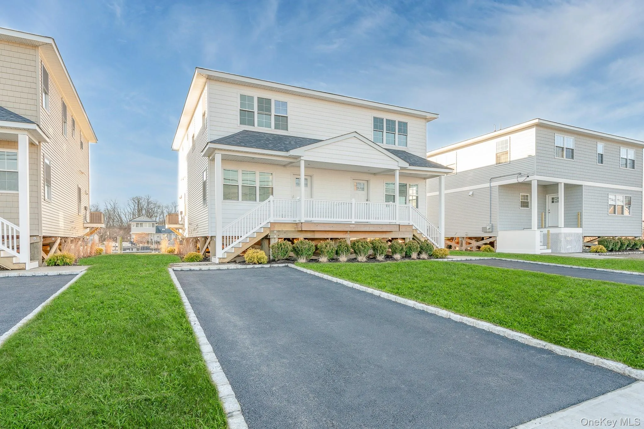 View of front of property featuring covered porch, roof with shingles, a front lawn, and stairway View of front of property featuring covered porch, roof with shingles, a front lawn, and stairway