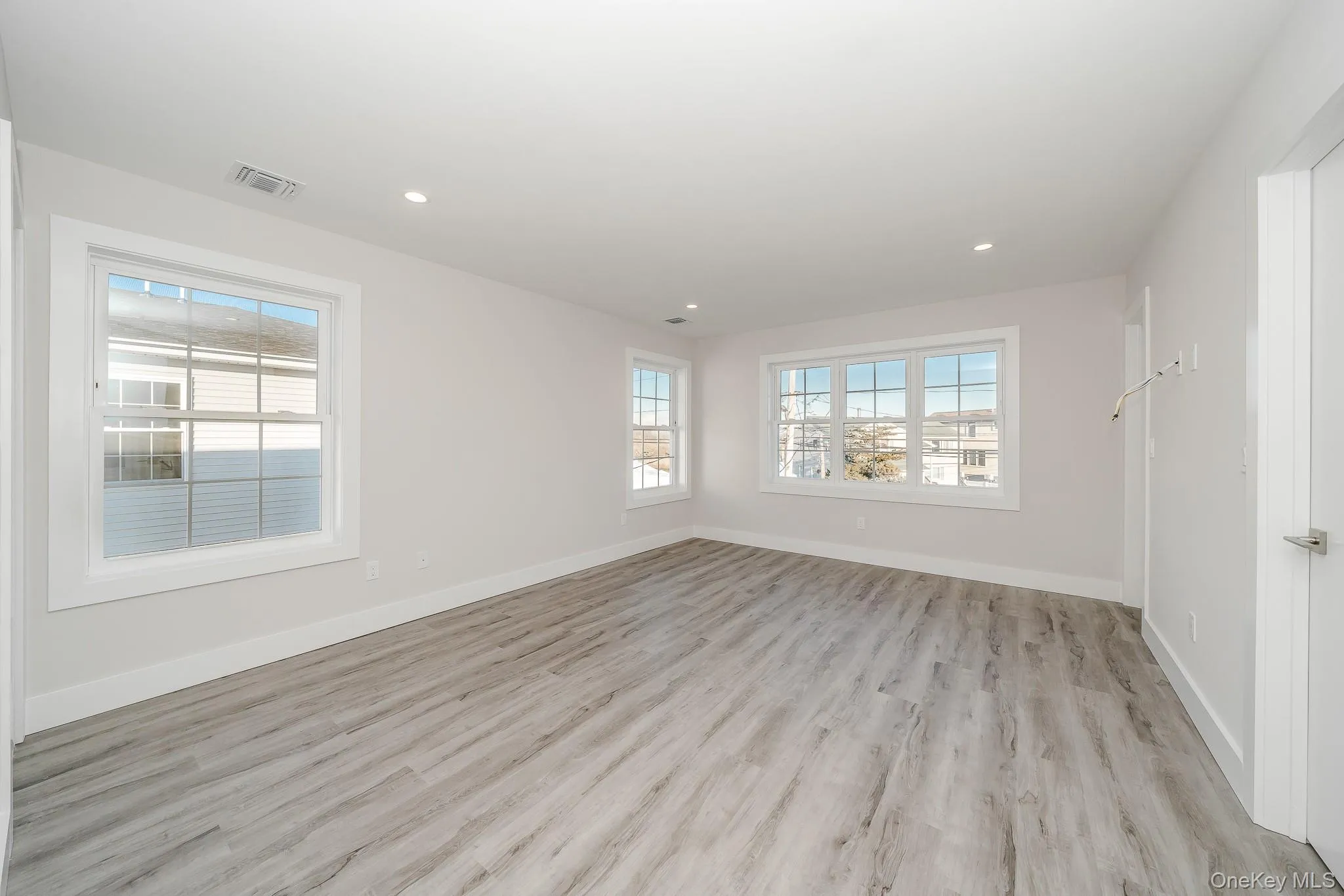 Empty room with light wood-style flooring and recessed lighting Empty room with light wood-style flooring and recessed lighting