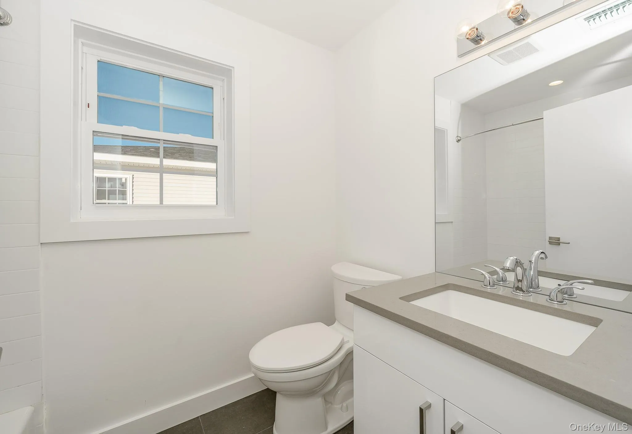 Bathroom with vanity and dark tile patterned floors Bathroom with vanity and dark tile patterned floors